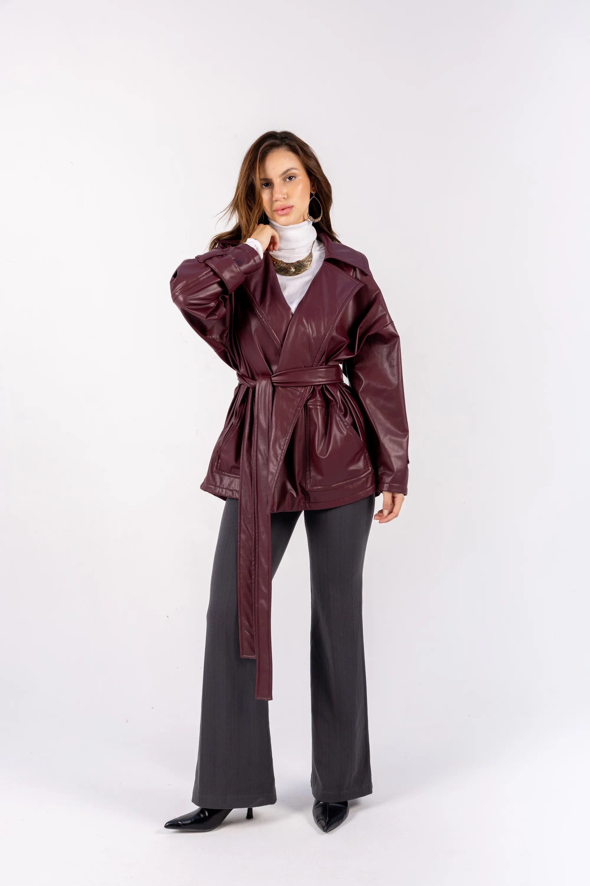 Woman wearing a burgundy trench coat on a white background