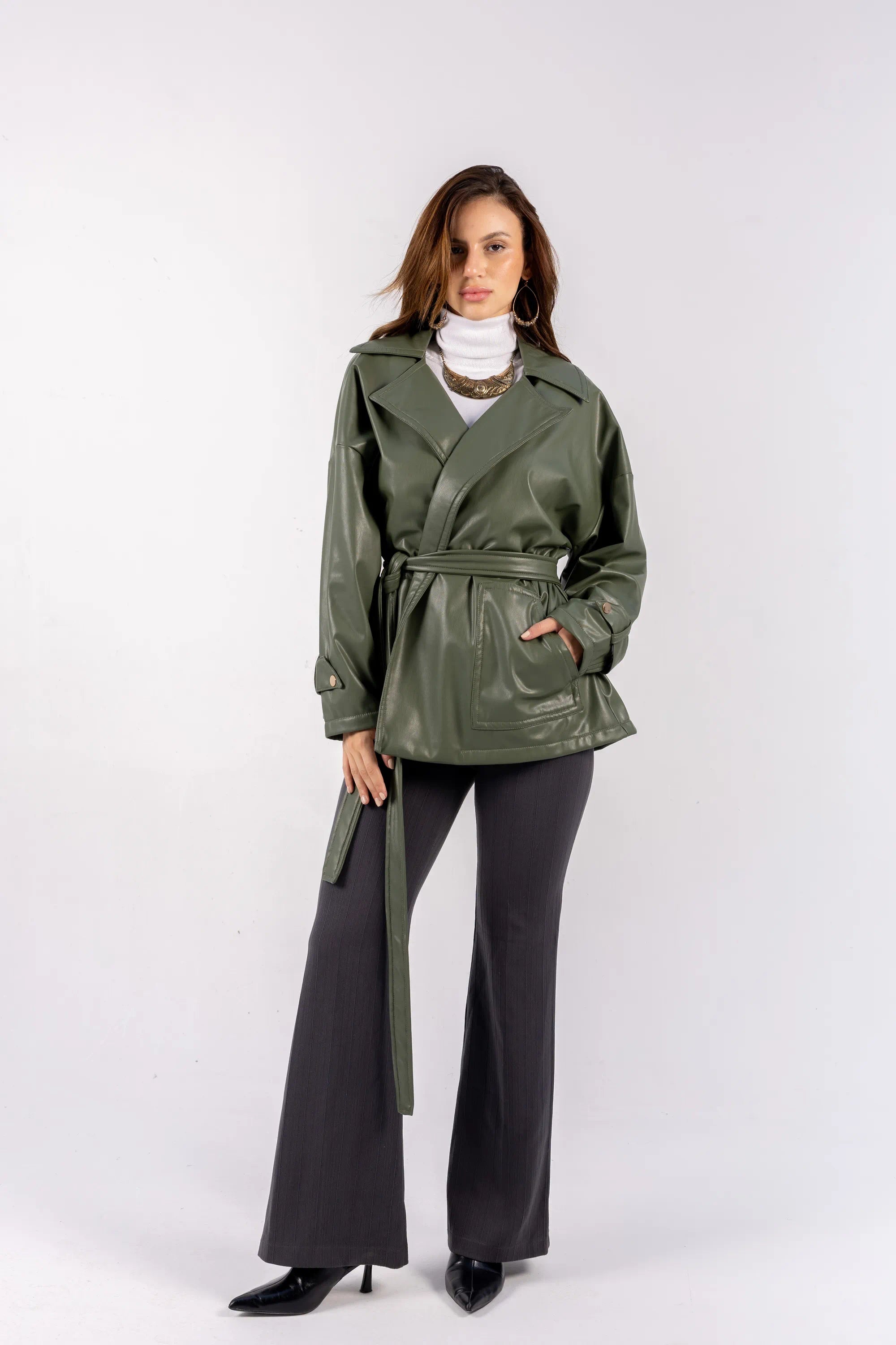 Woman wearing a green raincoat with a white background