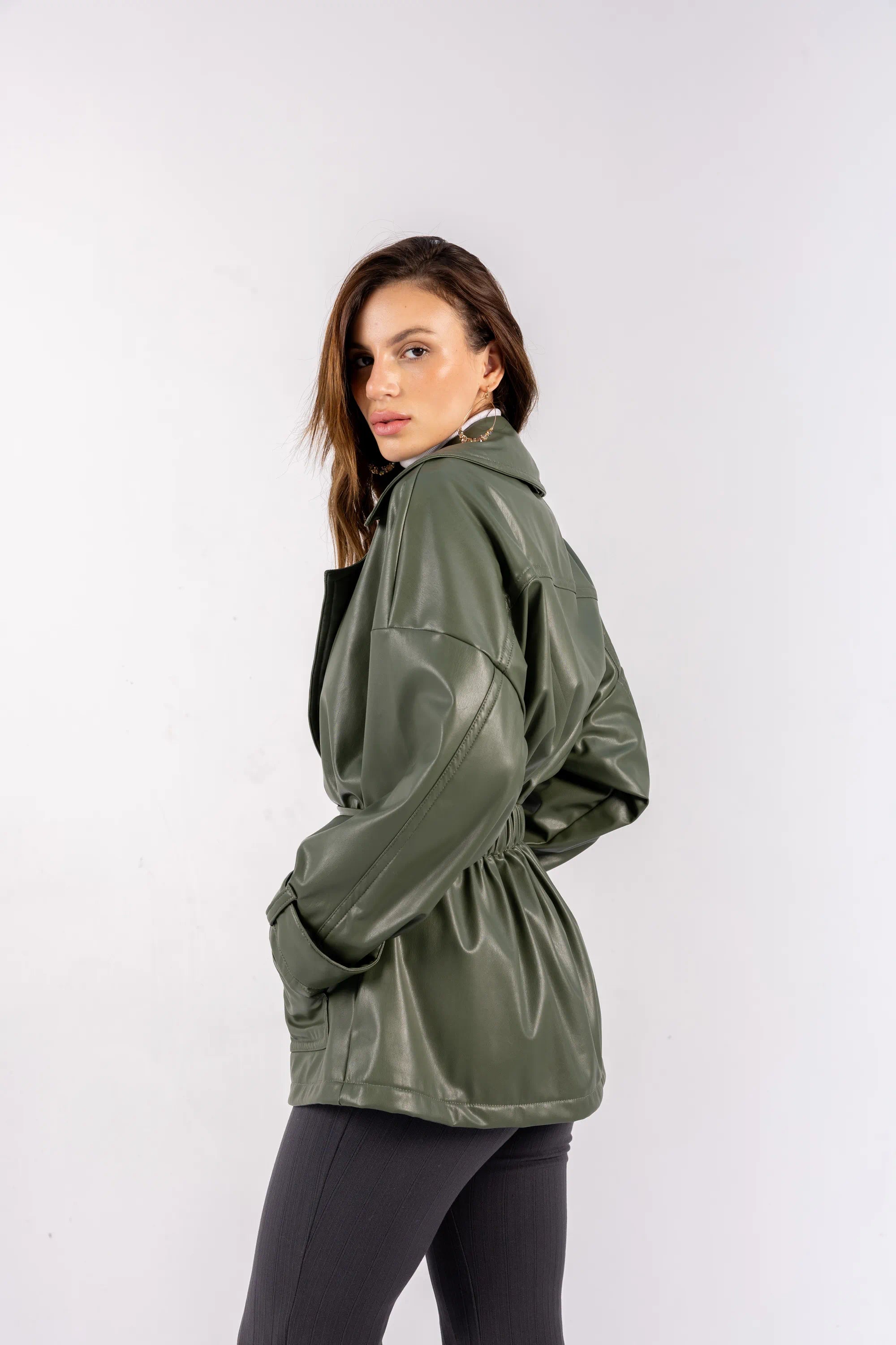 Woman wearing a green raincoat on a white background