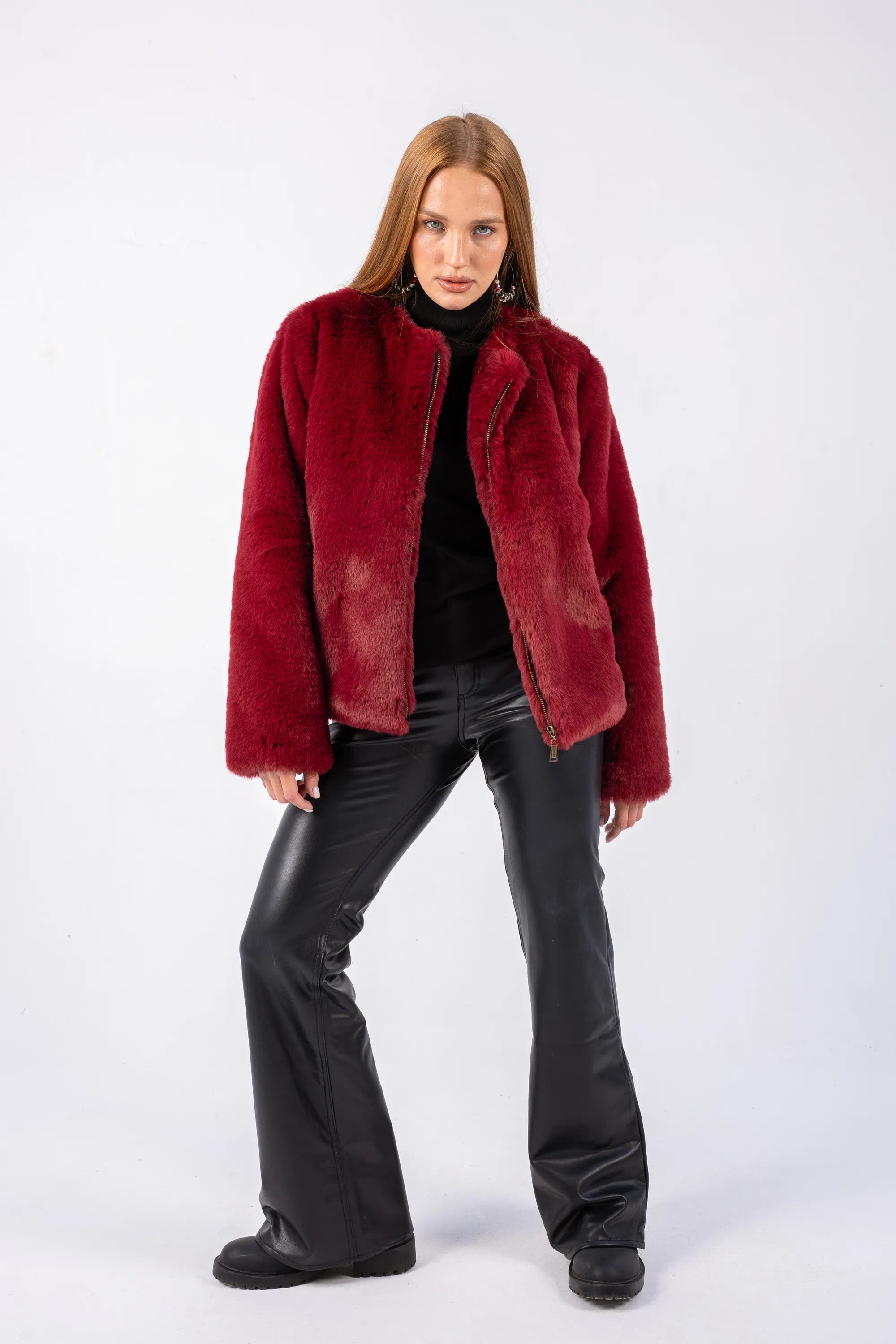 Woman wearing a red jacket and black pants on a white background