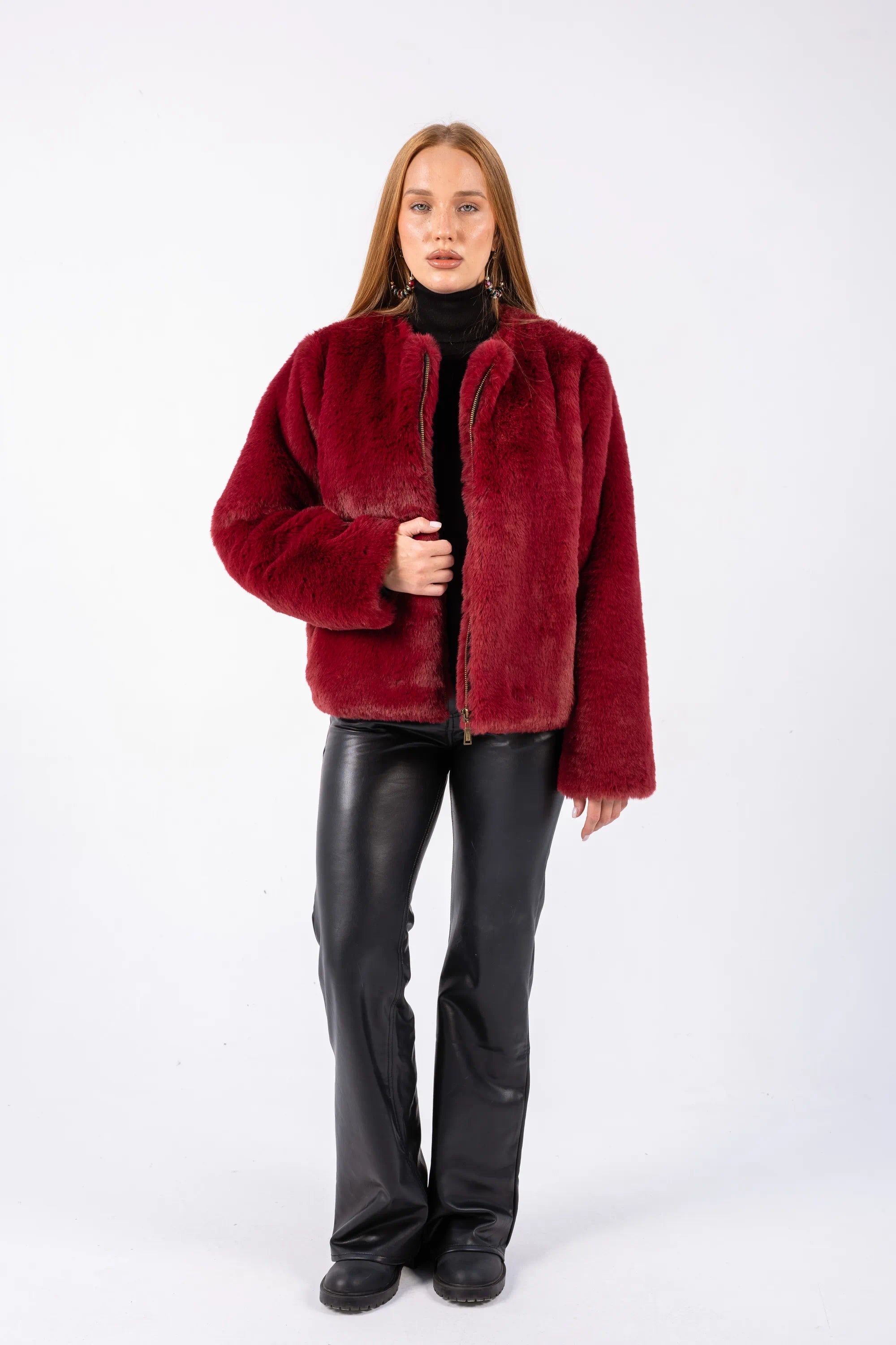 Person wearing a red faux fur jacket on a white background