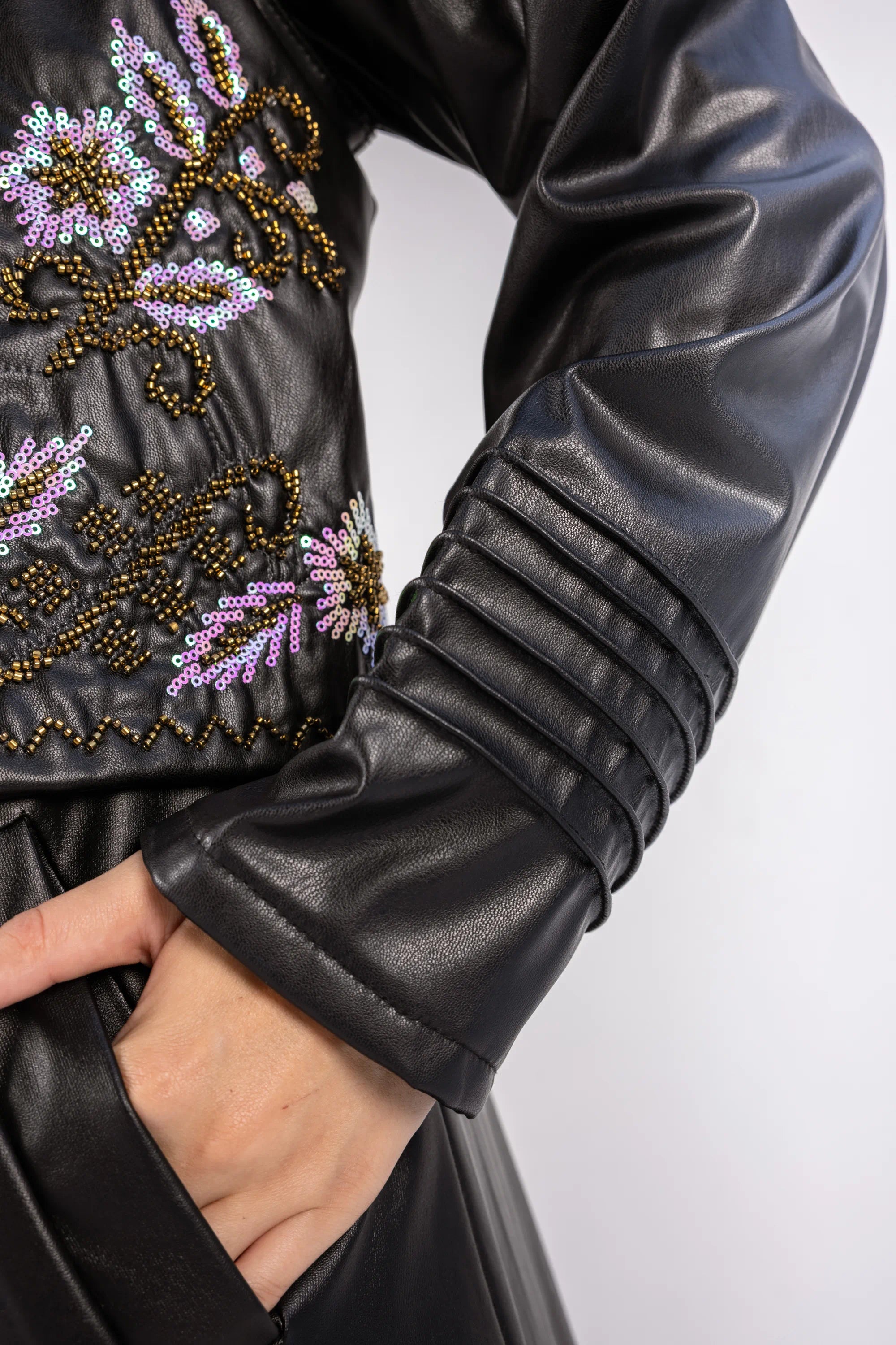 Black leather jacket with floral bead embroidery on a white background