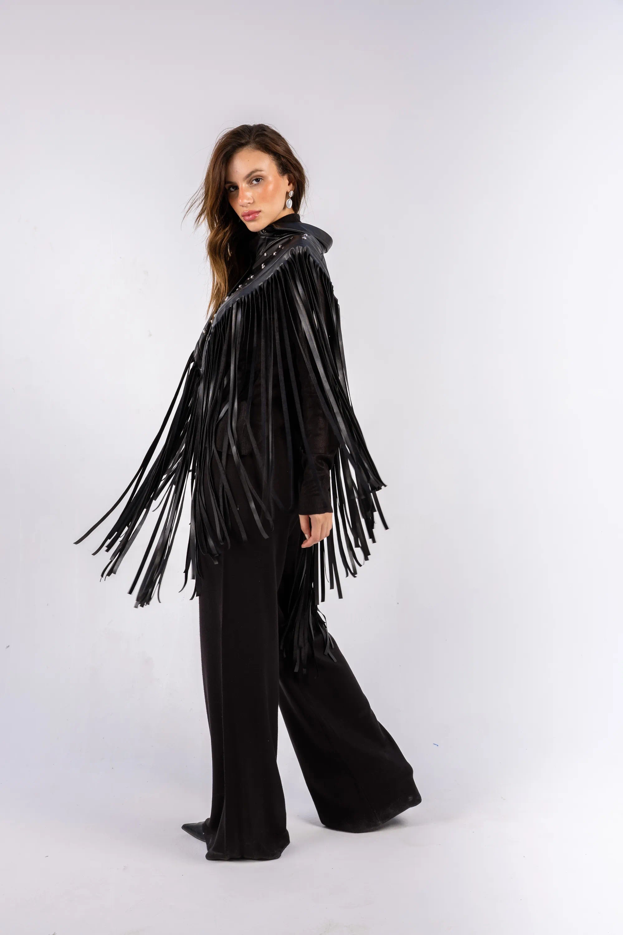 Woman wearing a black fringe outfit on a white background