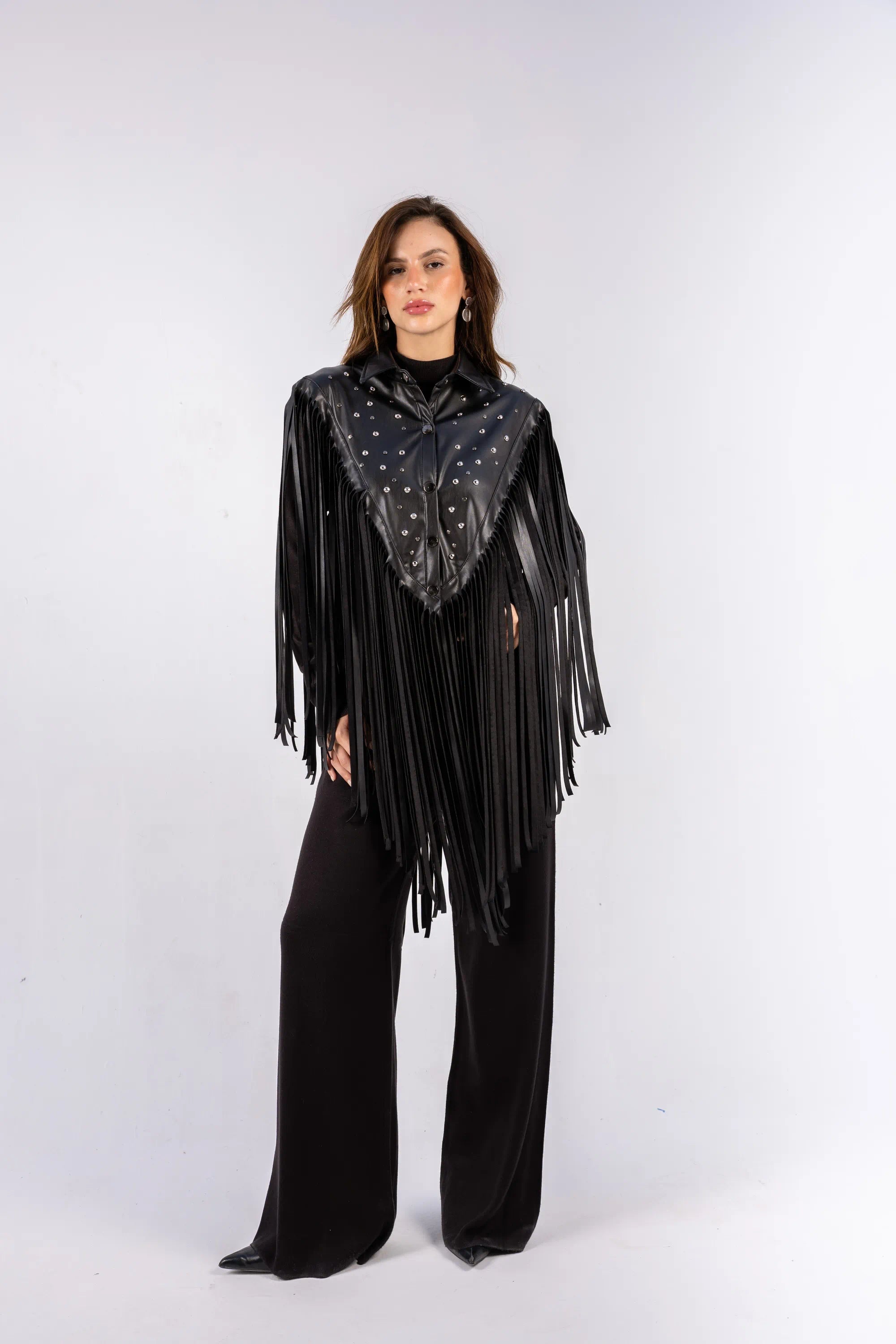 Woman wearing a black fringe outfit with a star-patterned top on a white background