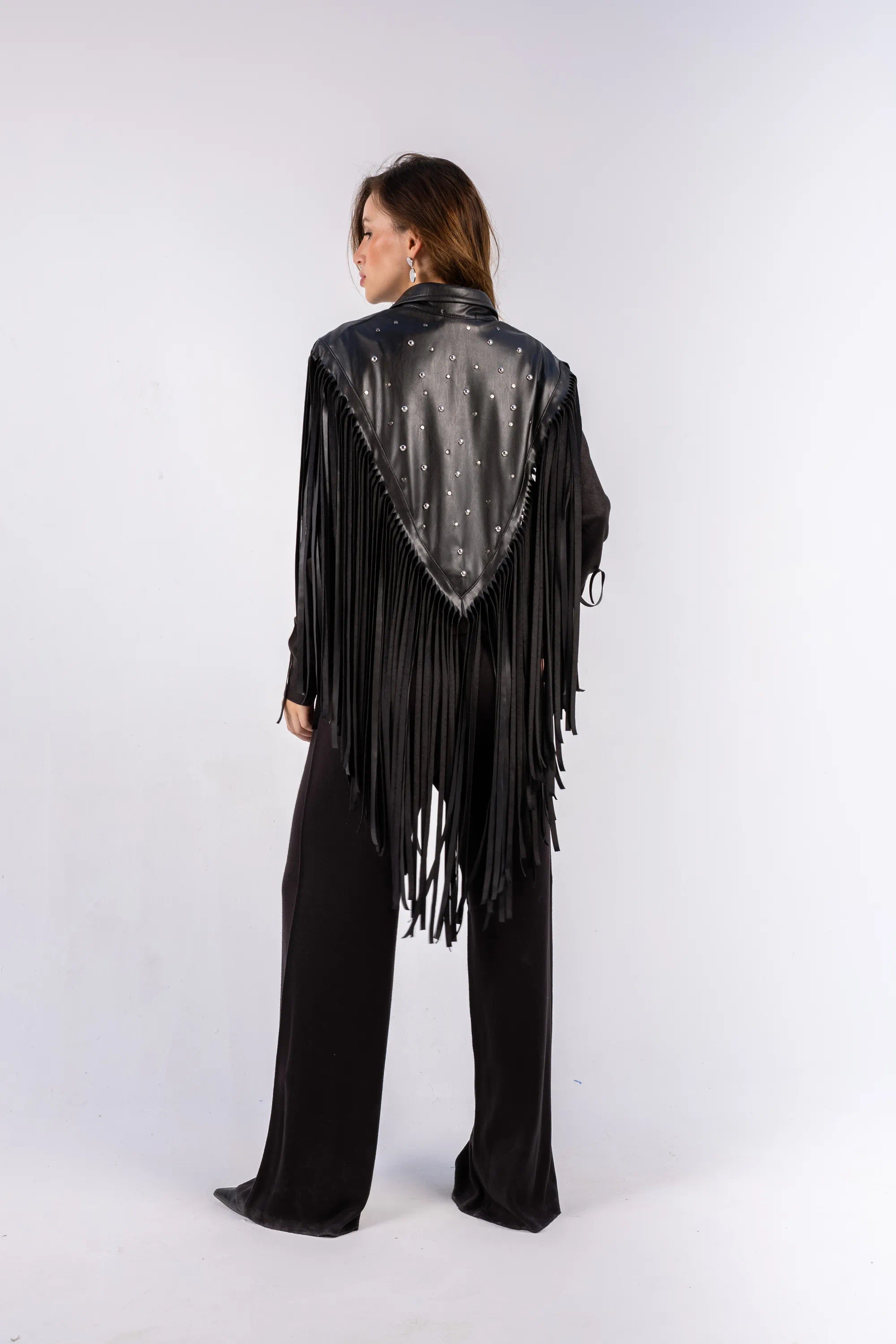 Person wearing a black fringe jacket with a white background