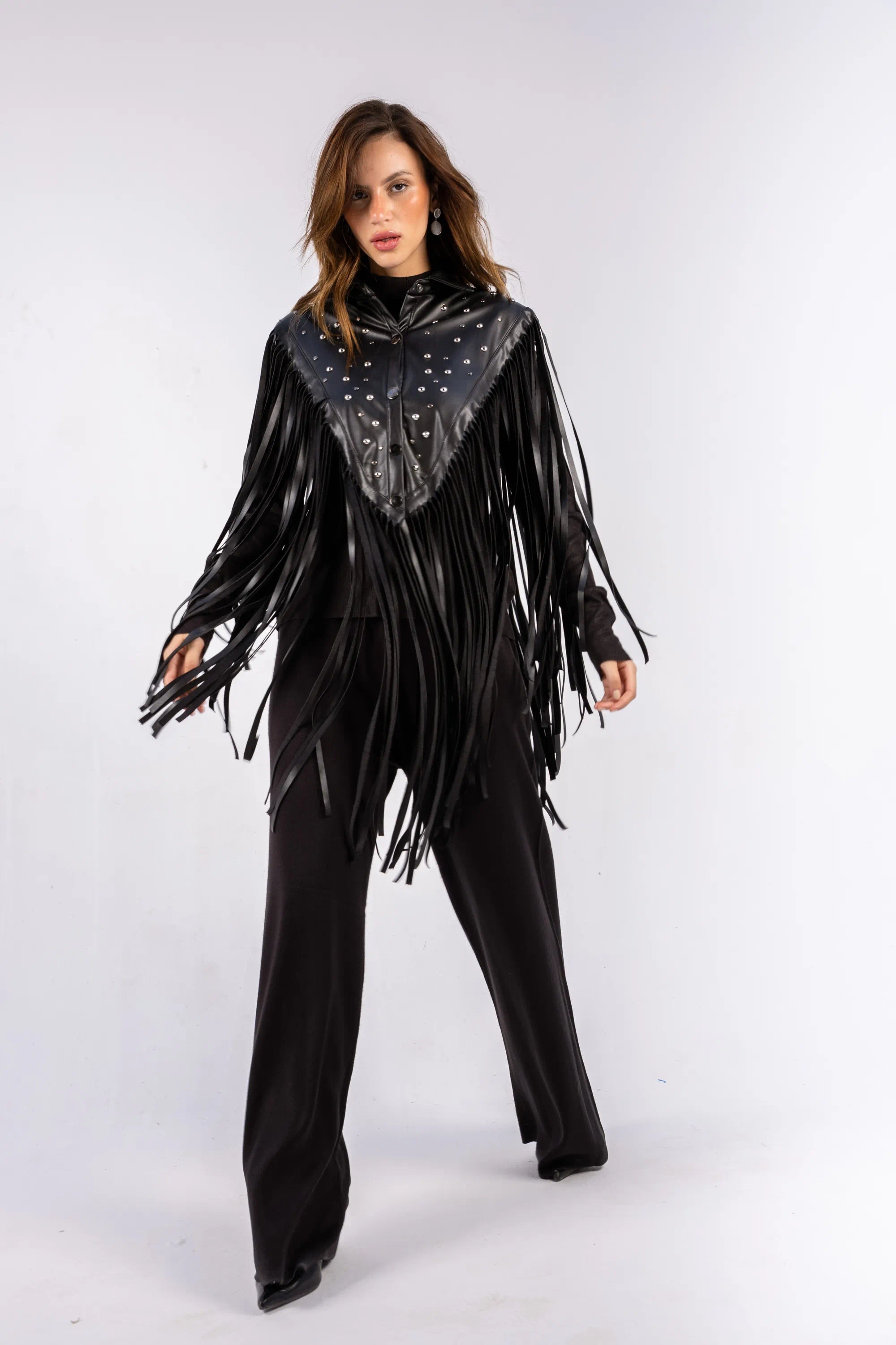 Woman wearing a black fringe outfit with a matching scarf on a white background