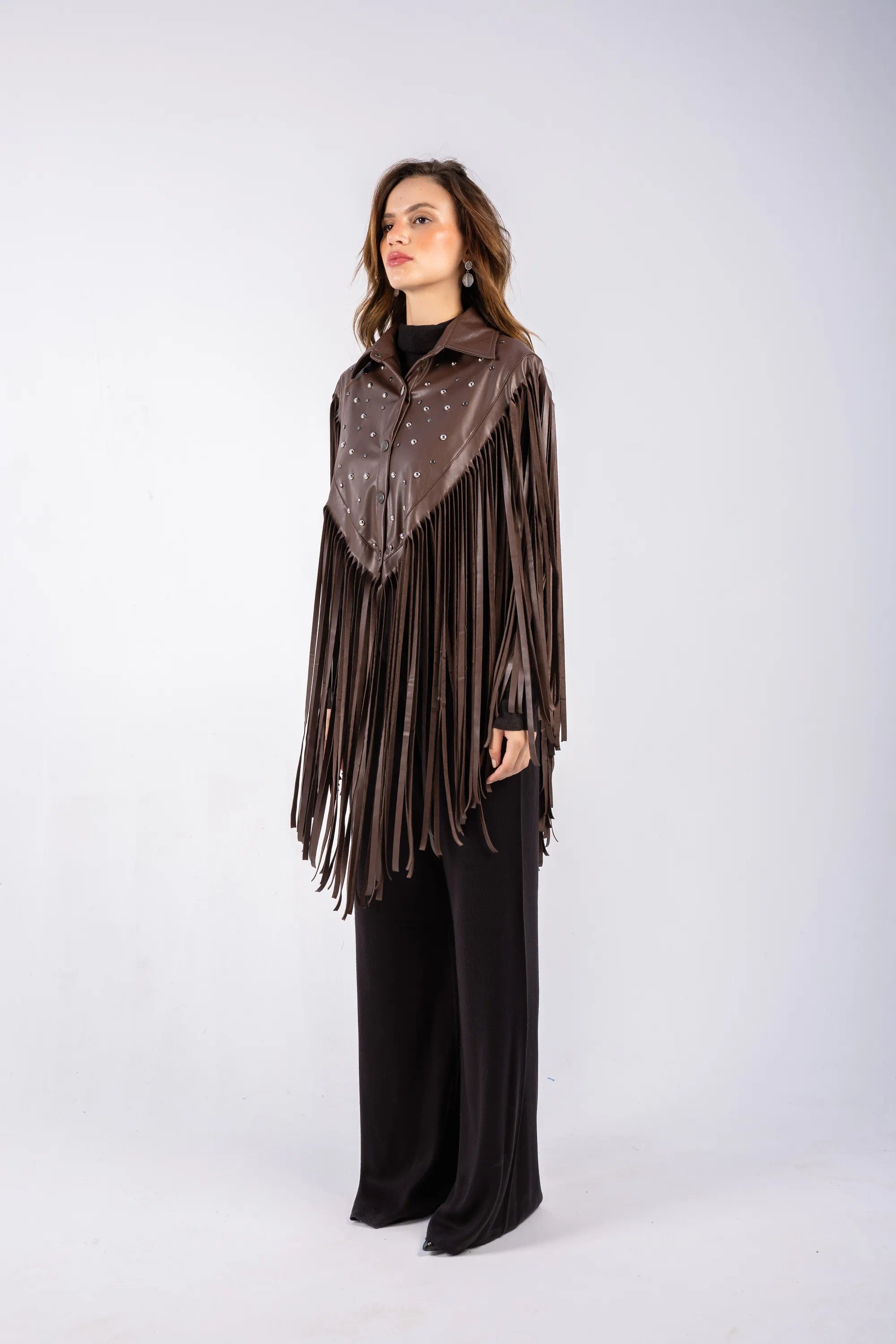 Woman wearing a brown fringe jacket and scarf on a white background