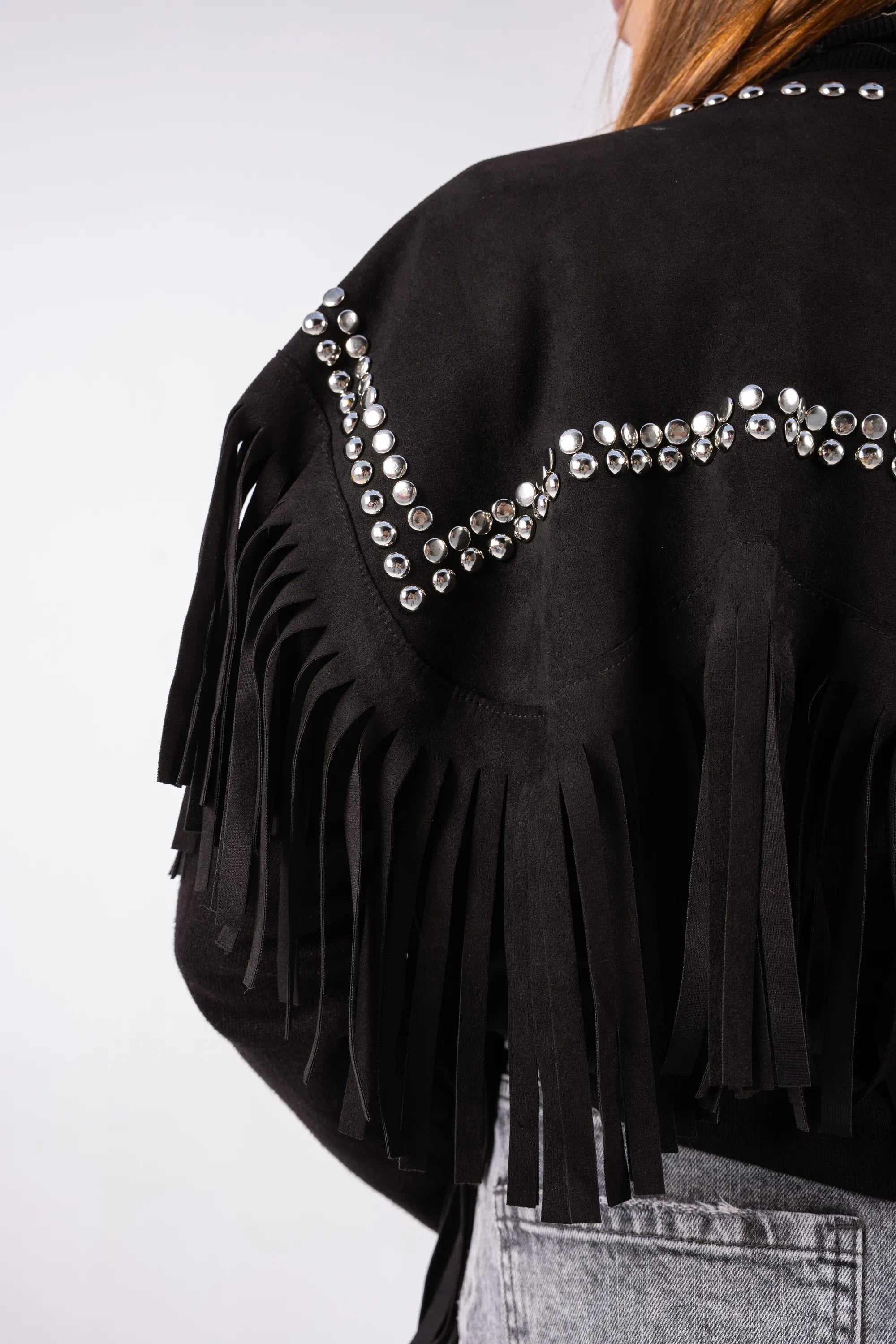 Black fringe jacket with decorative elements on a plain background