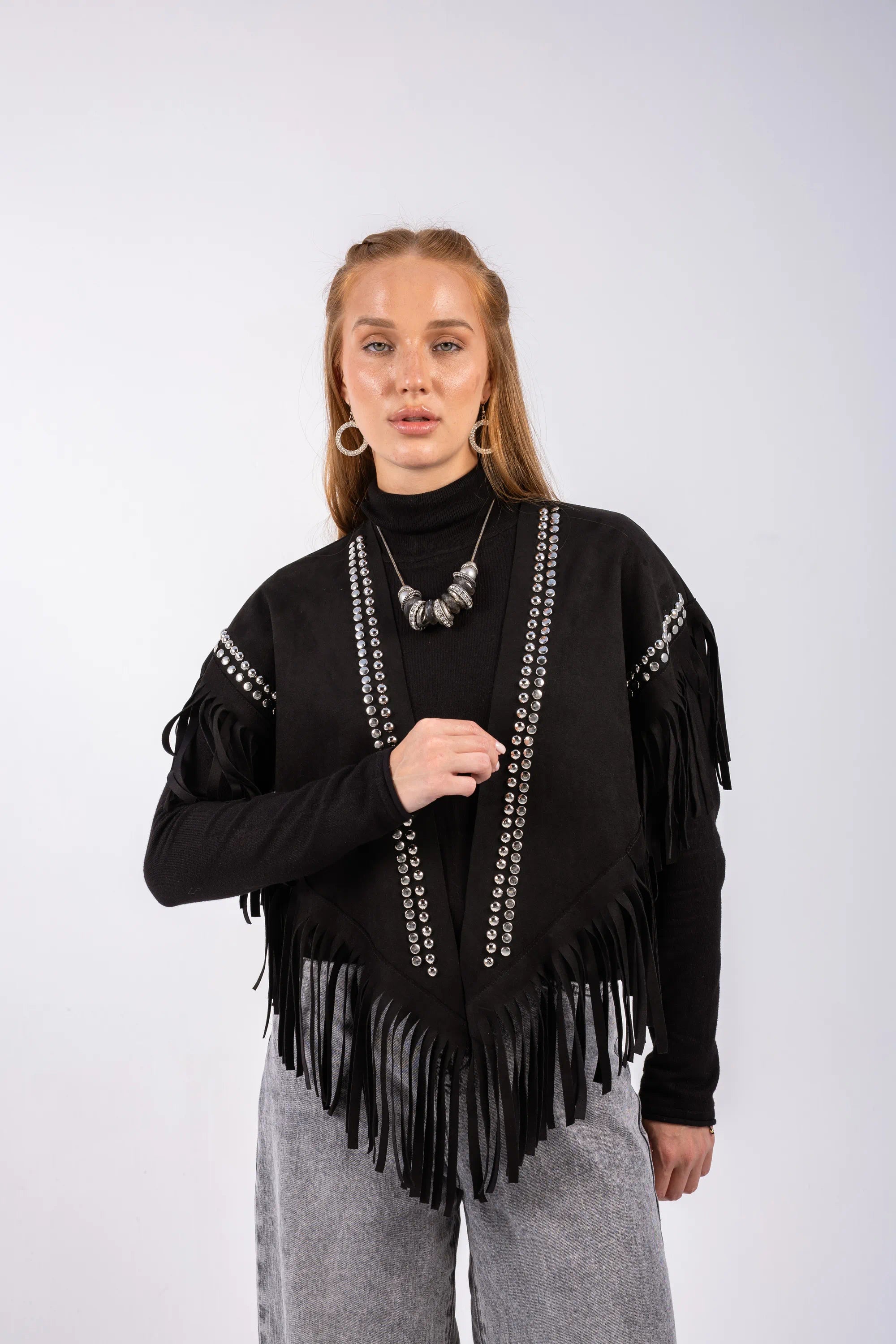 Woman wearing a black fringe sweater with white patterns on a white background