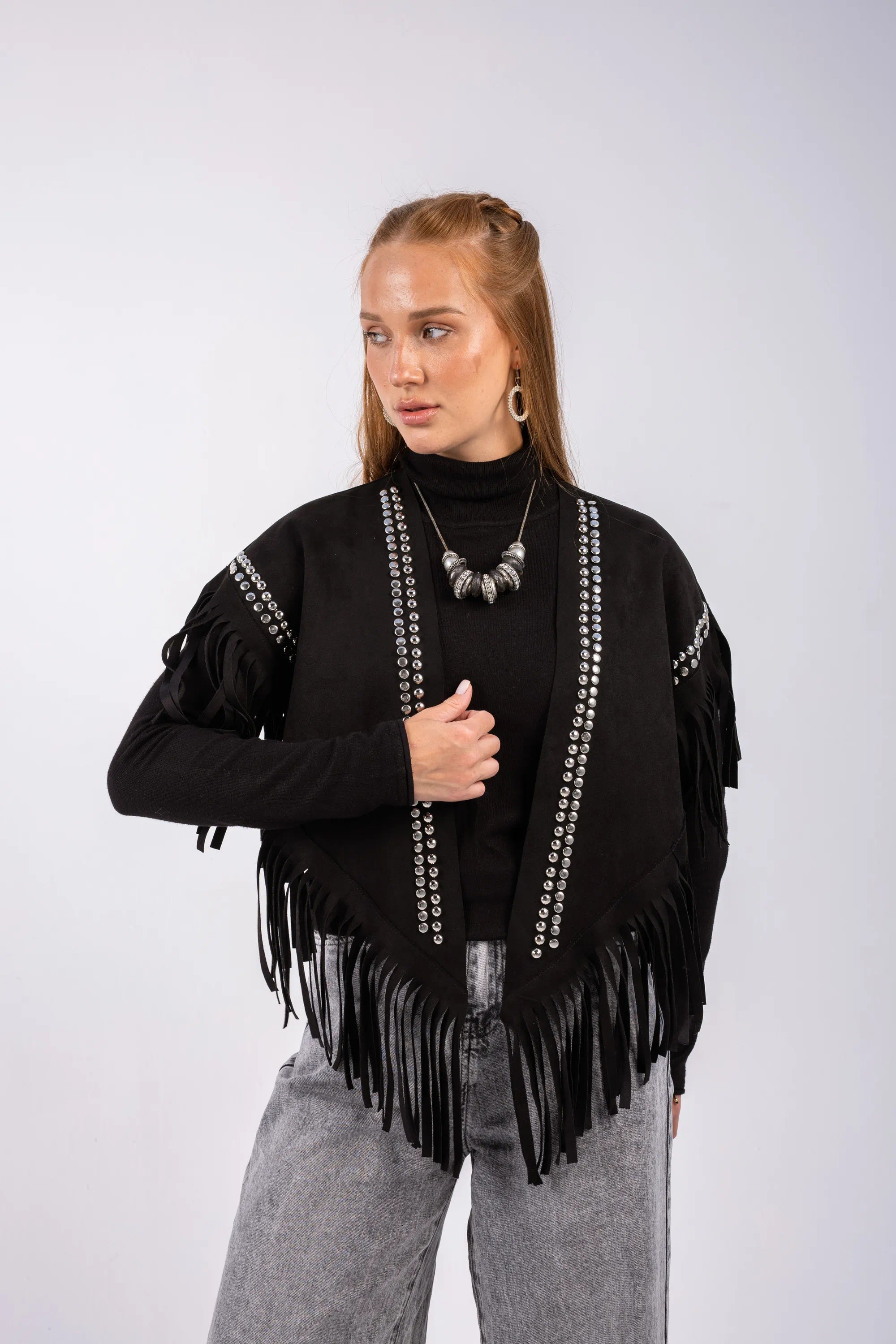 Woman wearing a black fringe jacket with white patterns on a white background