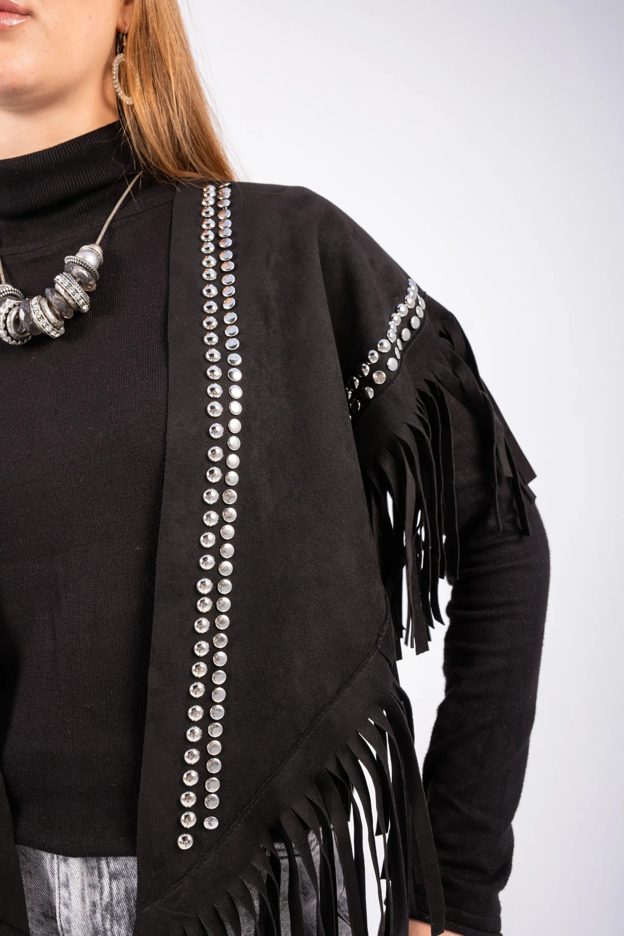 Black fringe garment with decorative elements on a plain background