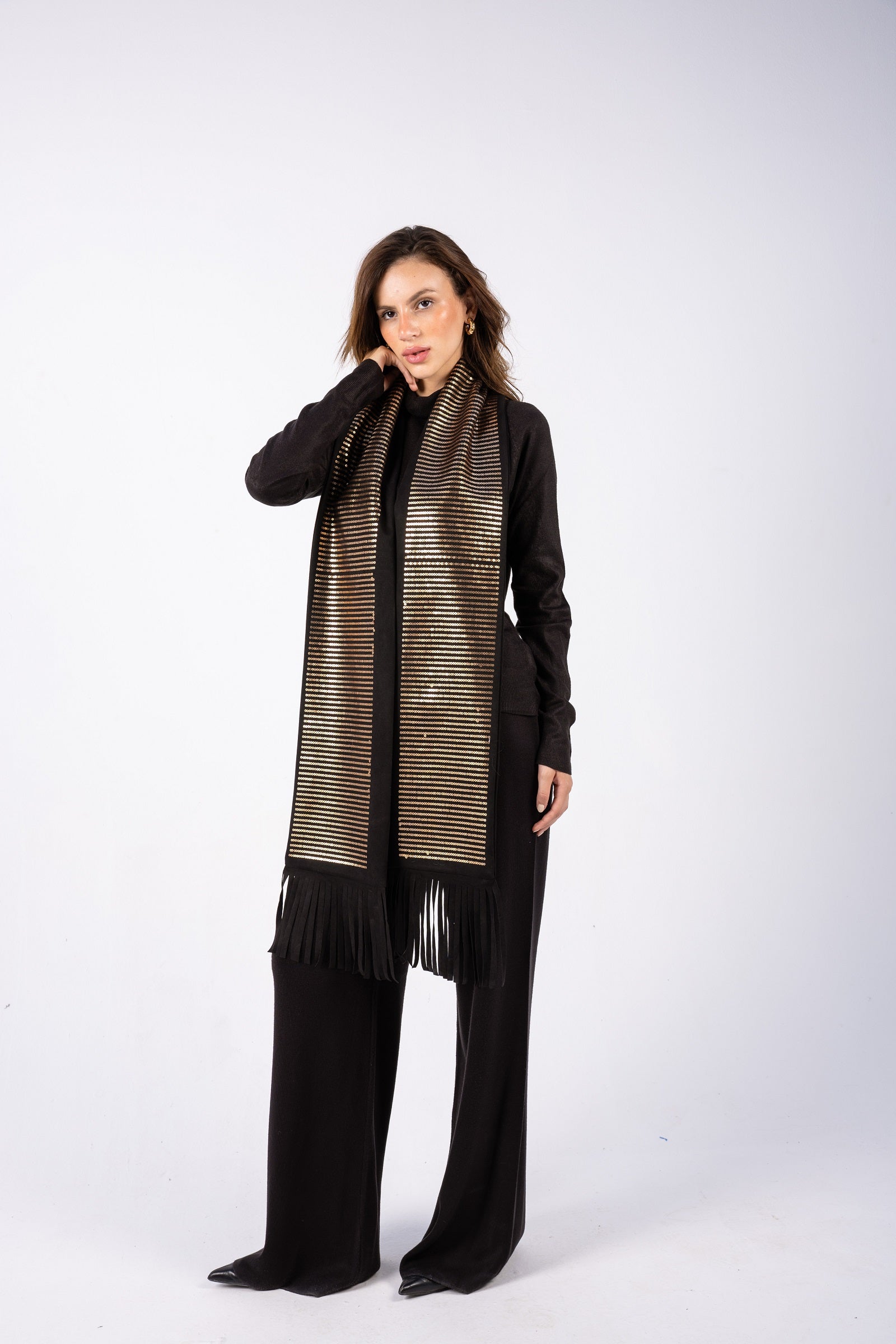 Woman wearing a long, patterned scarf with a plain background