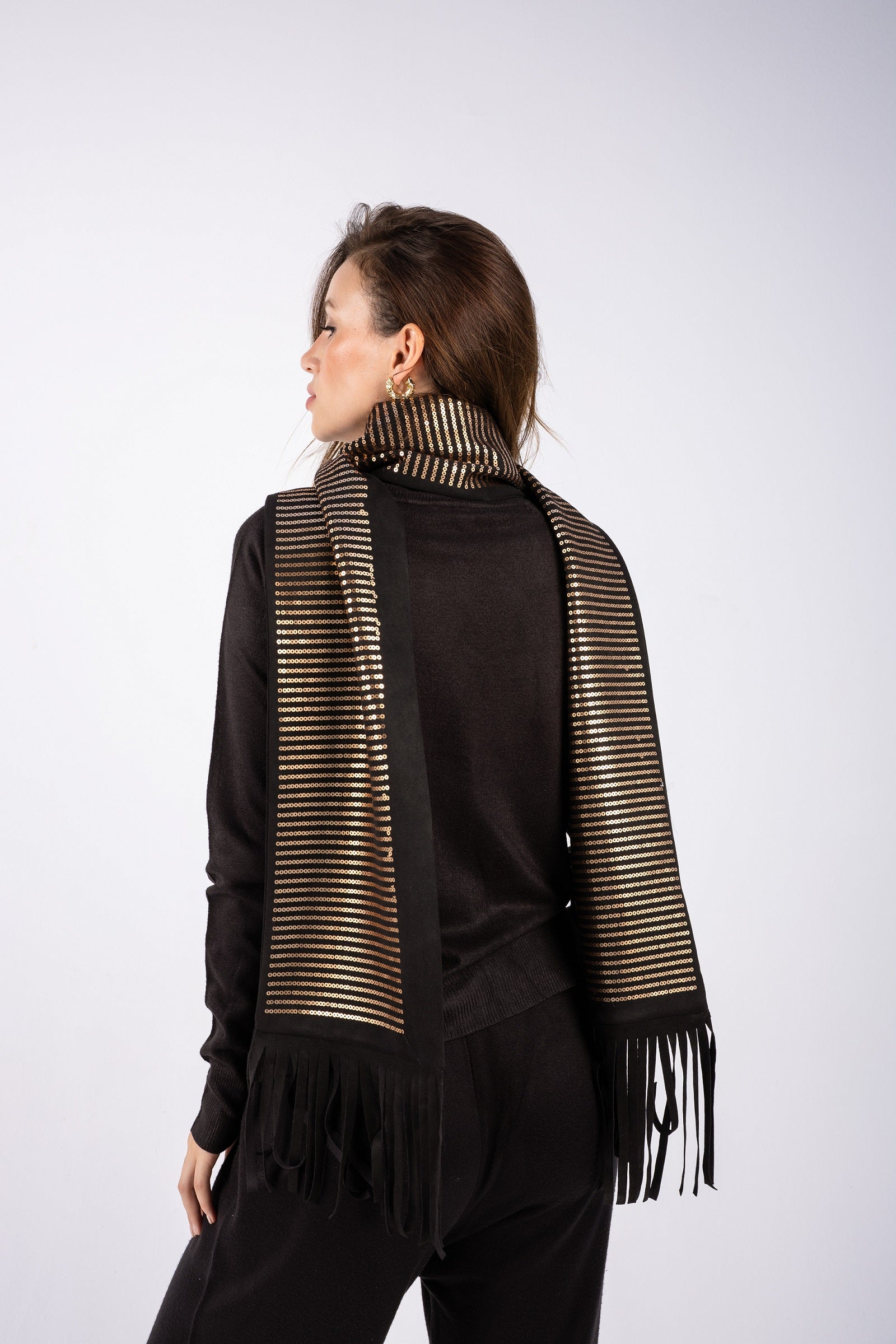 Woman wearing a black outfit with a striped scarf on a white background