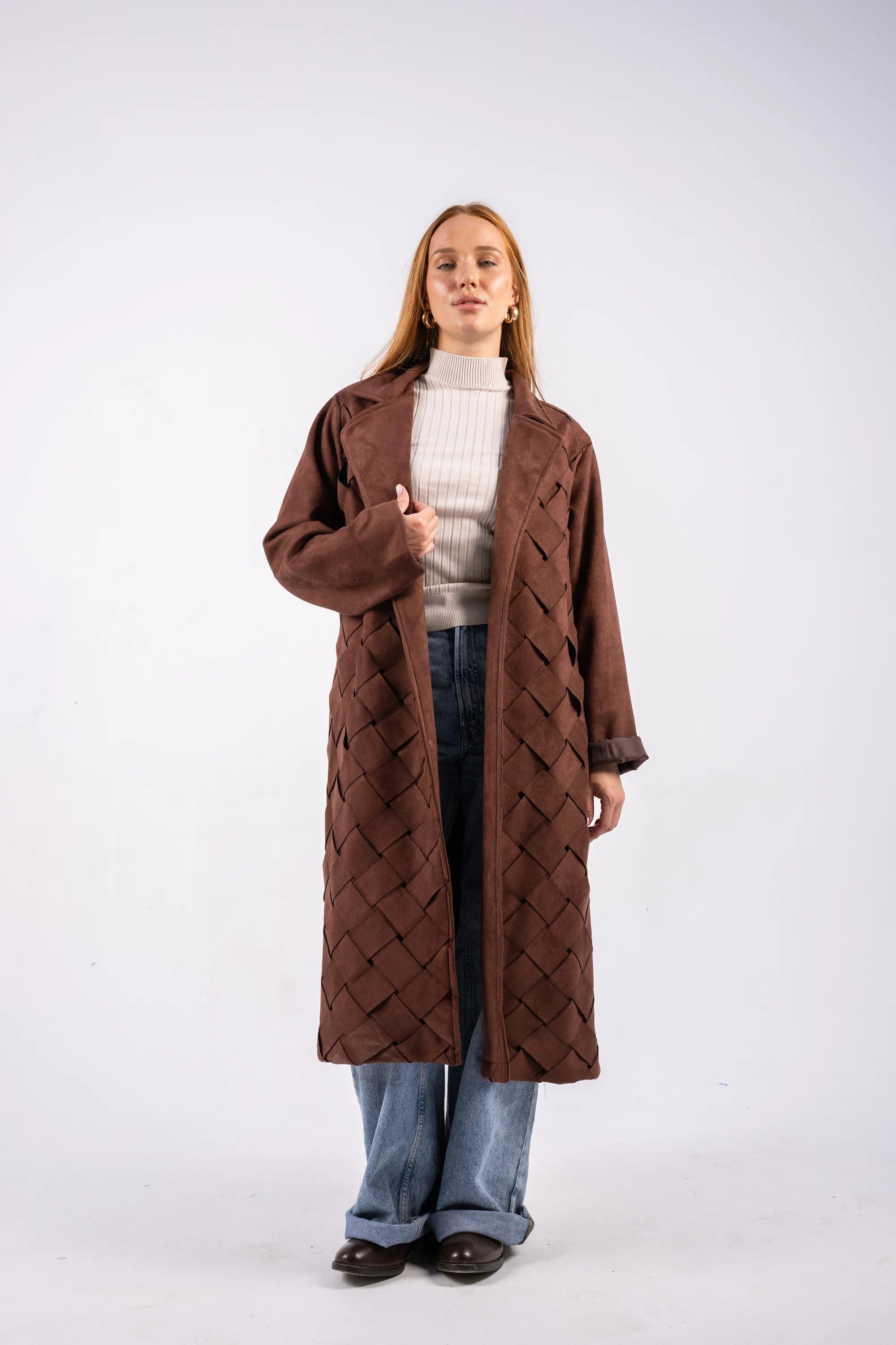 Person wearing a brown quilted coat on a white background