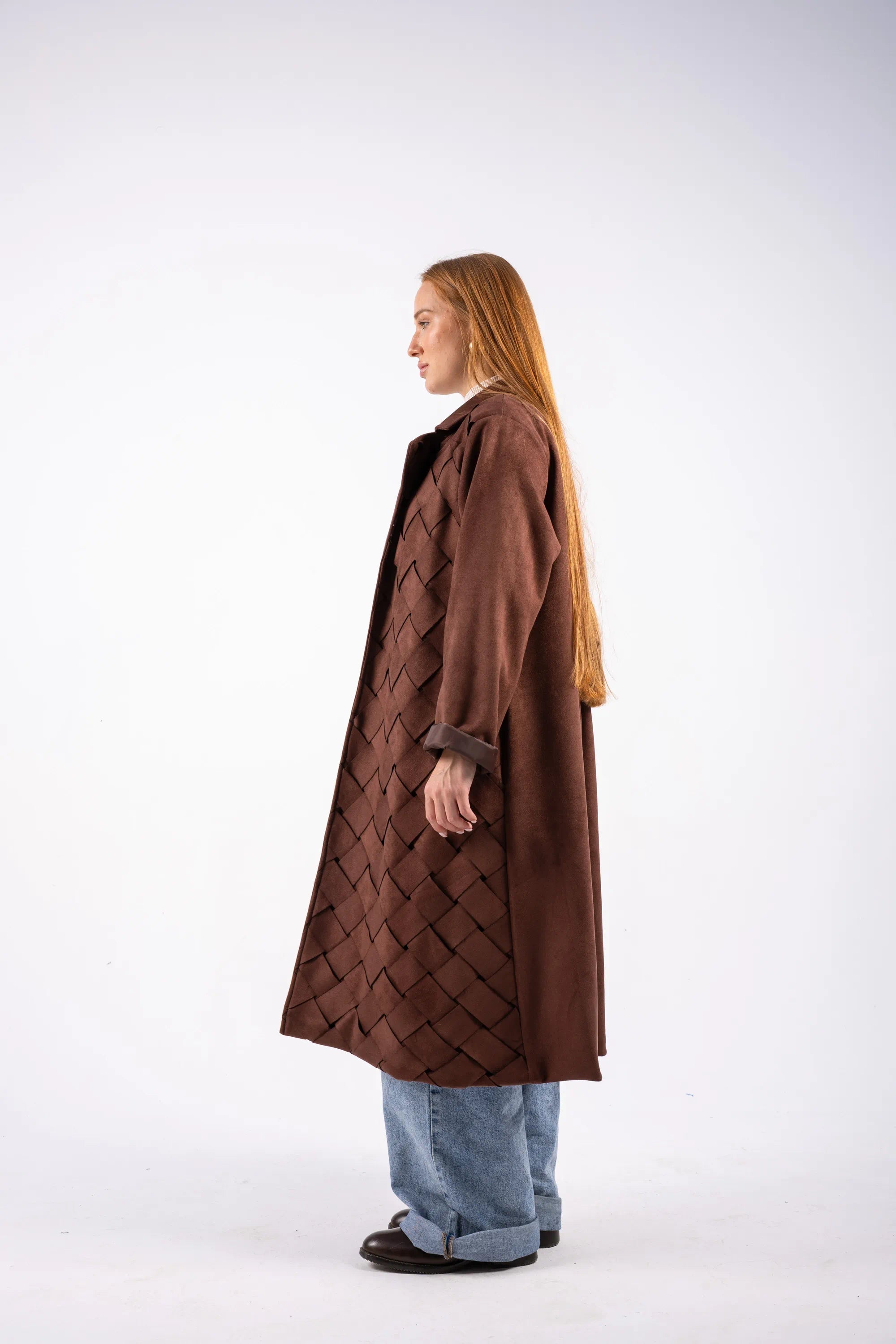 Person wearing a brown quilted coat on a white background