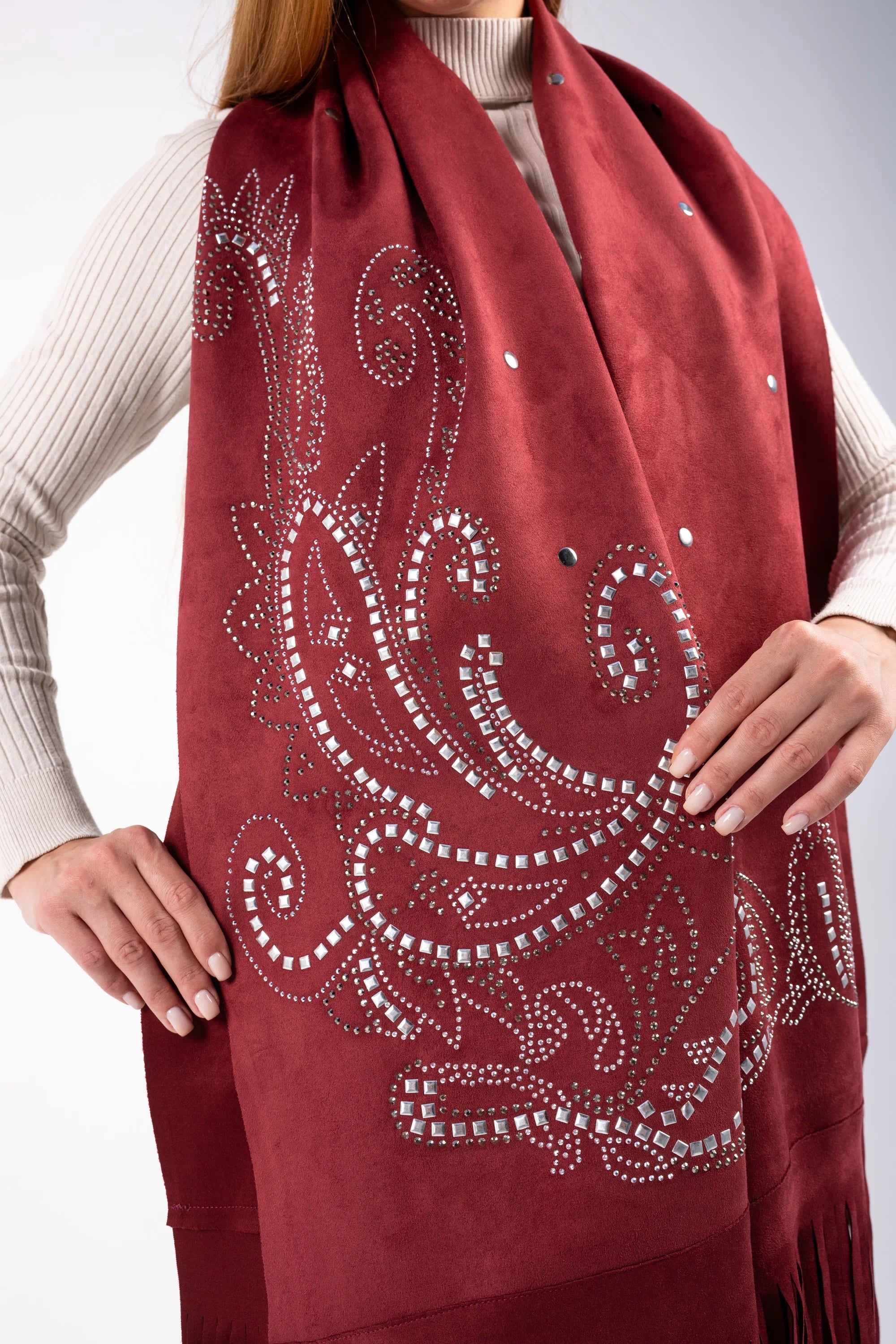 Red scarf with intricate white patterns and embellishments on a plain background