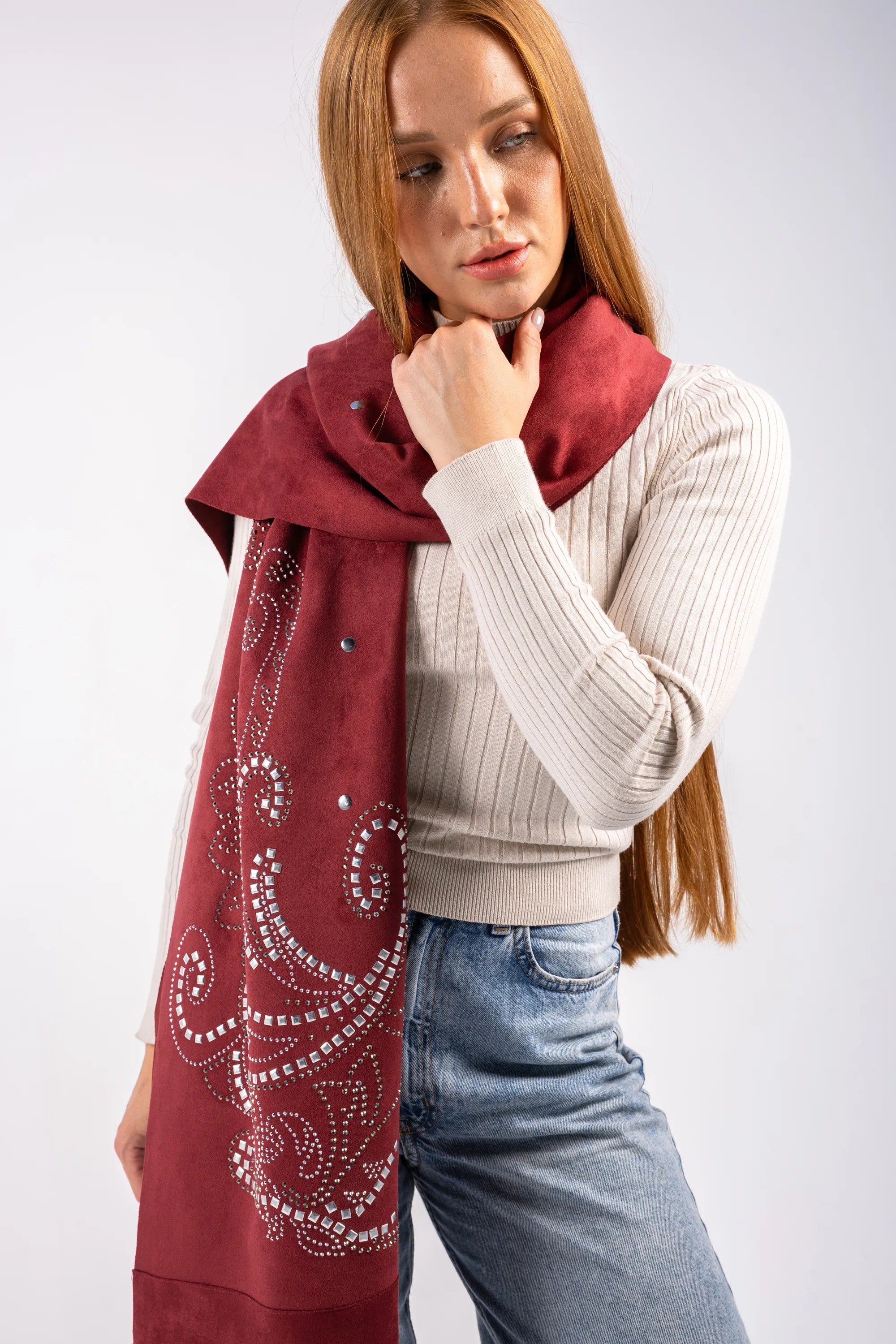Woman wearing a red scarf with white patterns on a plain background