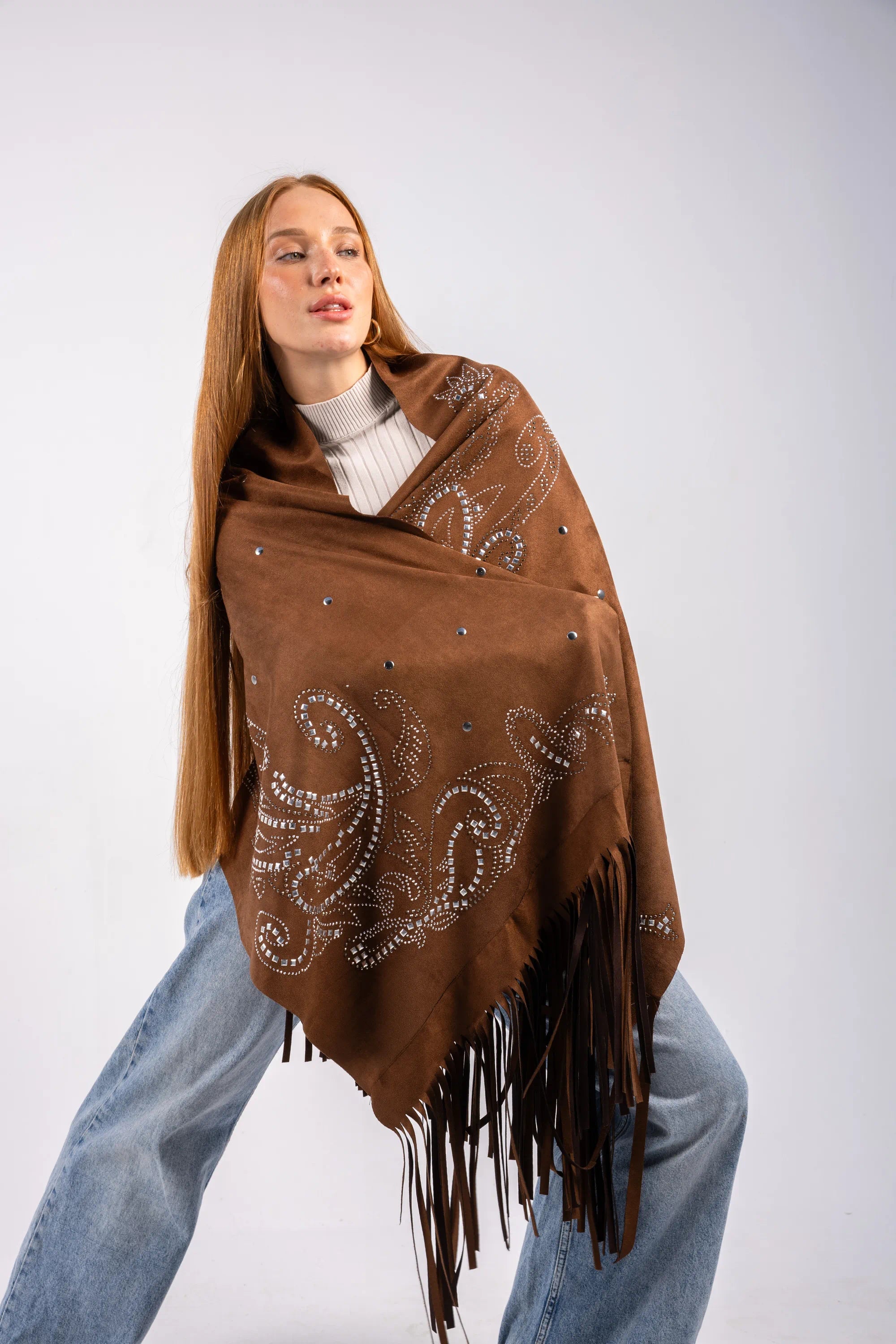 Woman wearing a brown patterned shawl with fringes on a white background