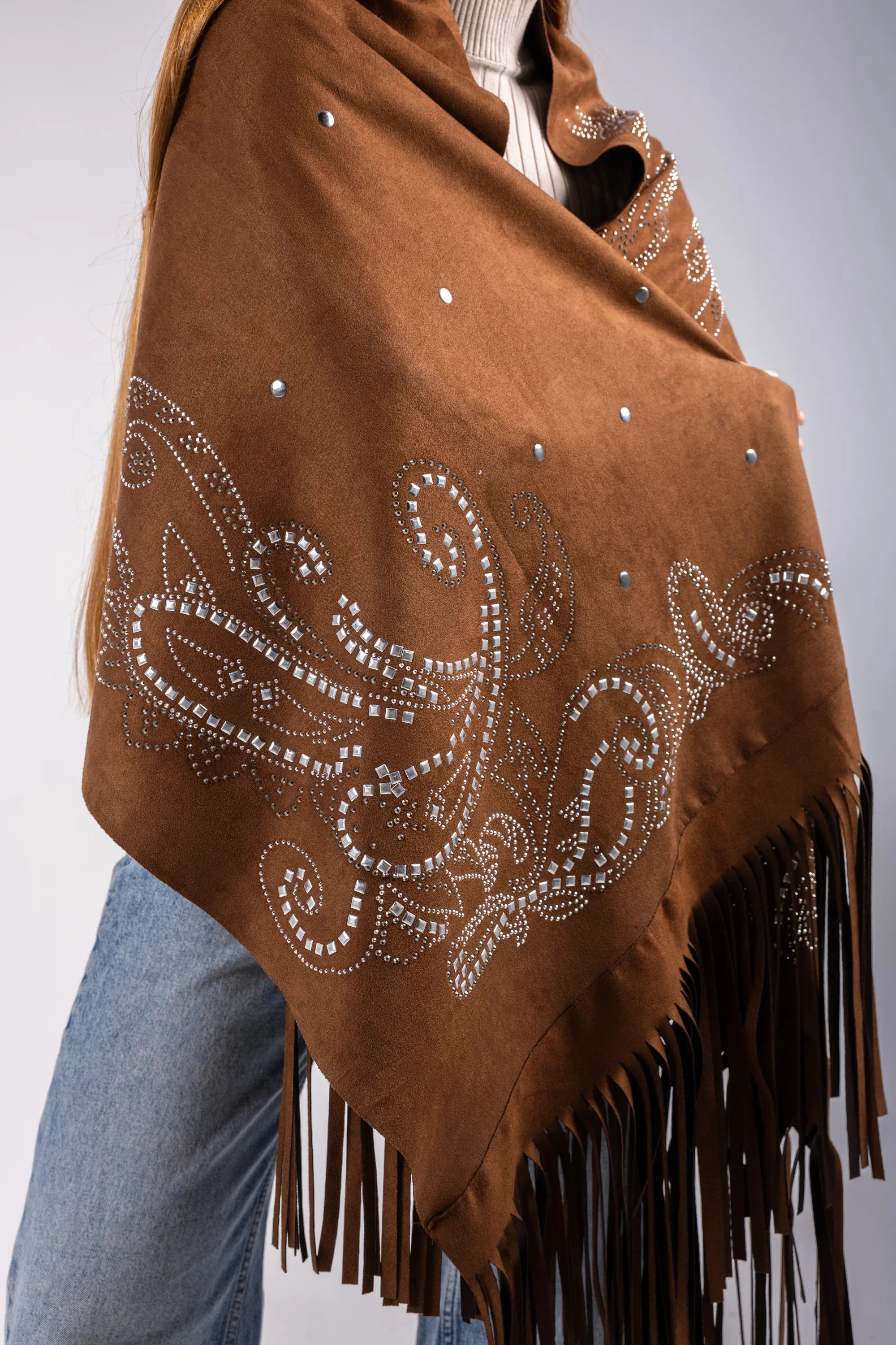 Brown shawl with decorative patterns and fringes on a plain background