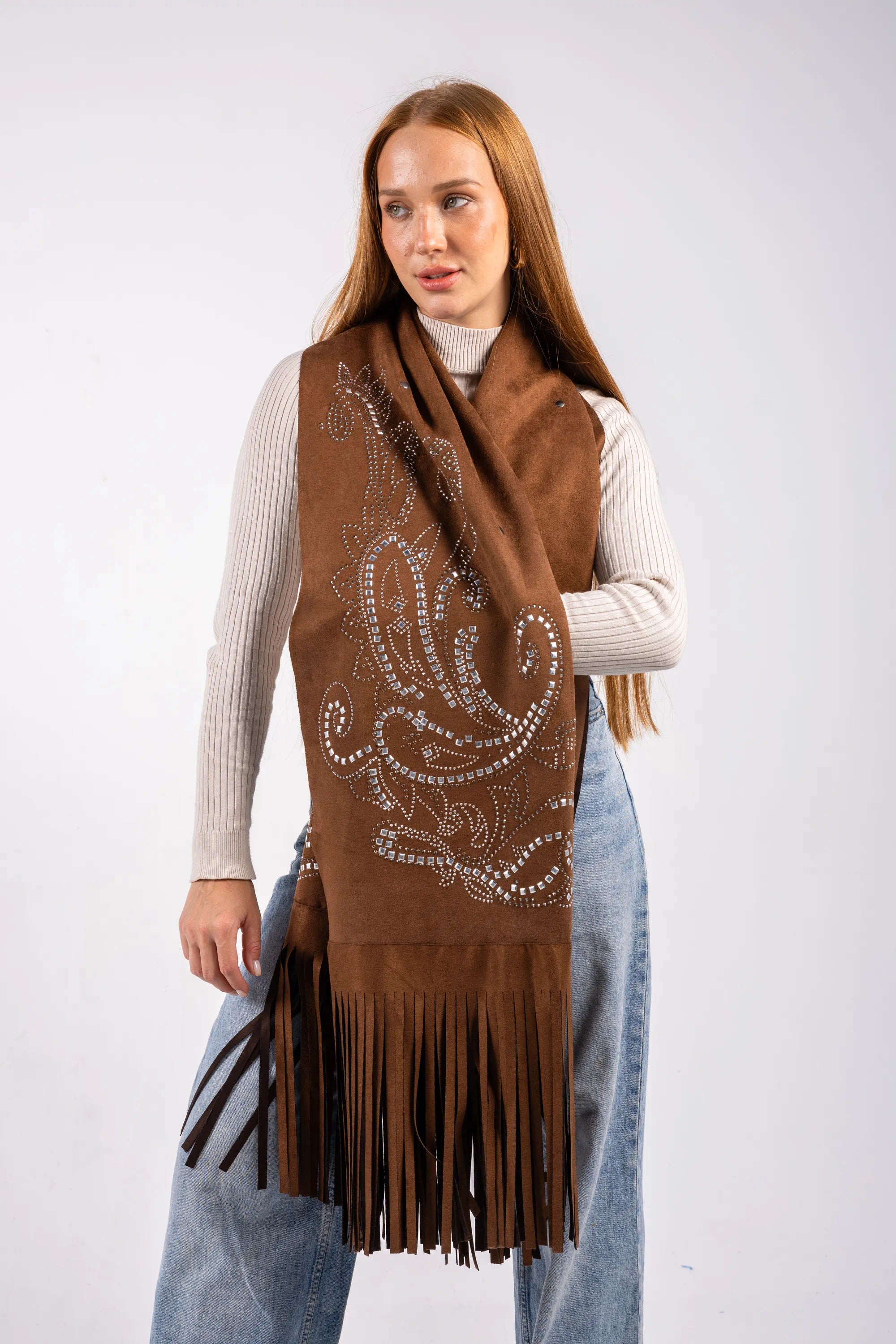 Woman wearing a brown scarf with intricate patterns and fringes on a white background