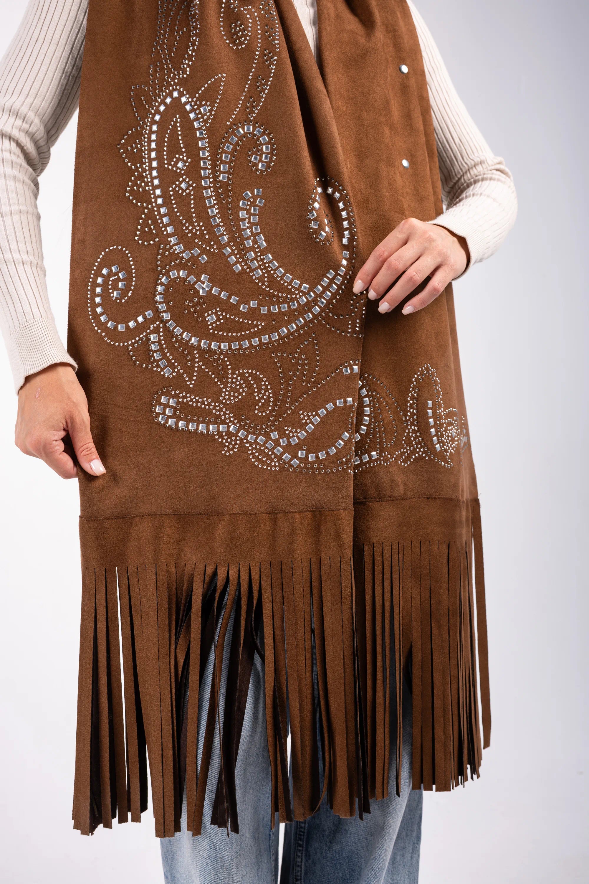 Brown suede vest with decorative patterns and fringes on a plain background