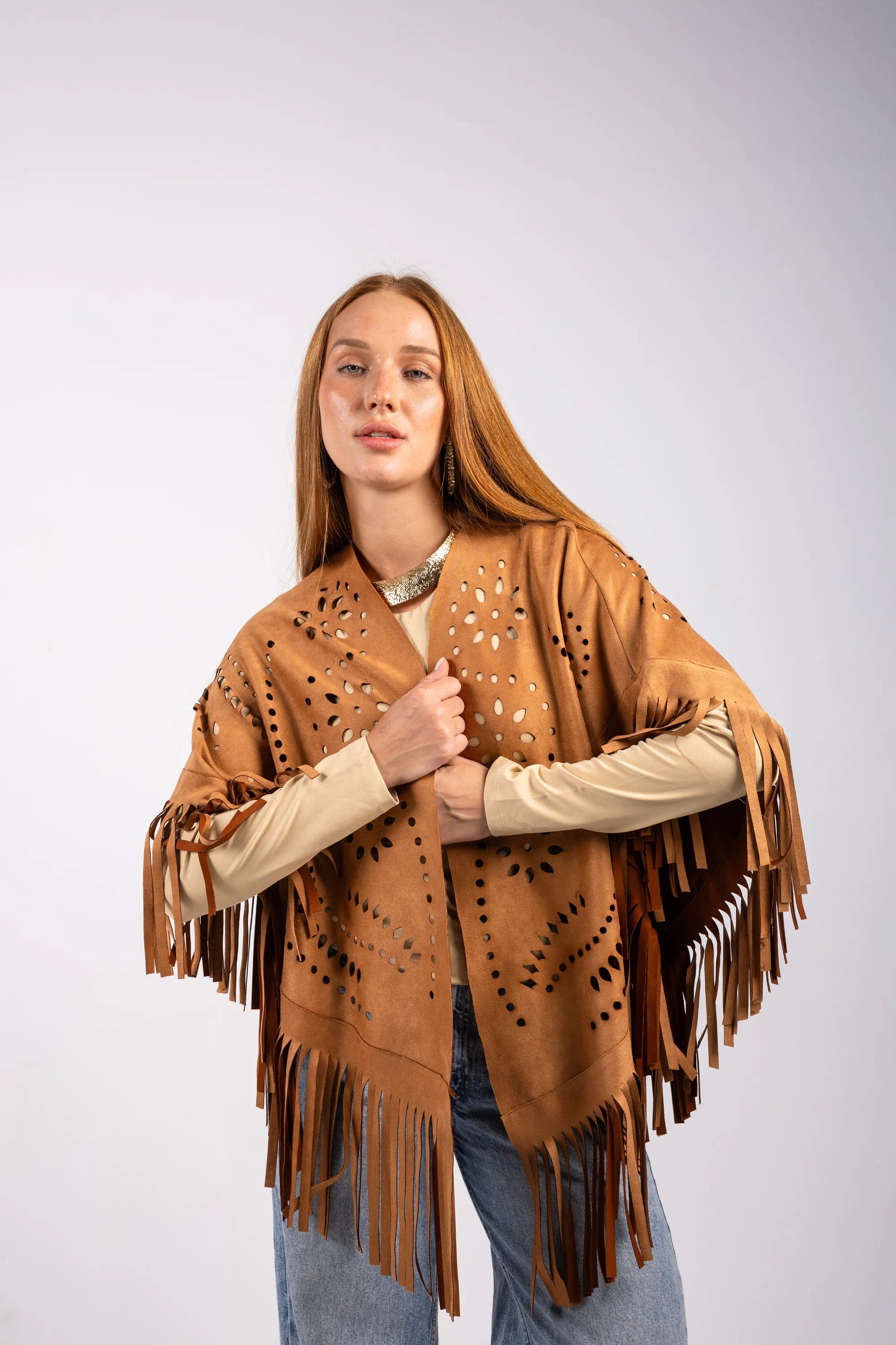 Woman wearing a brown fringe poncho on a white background