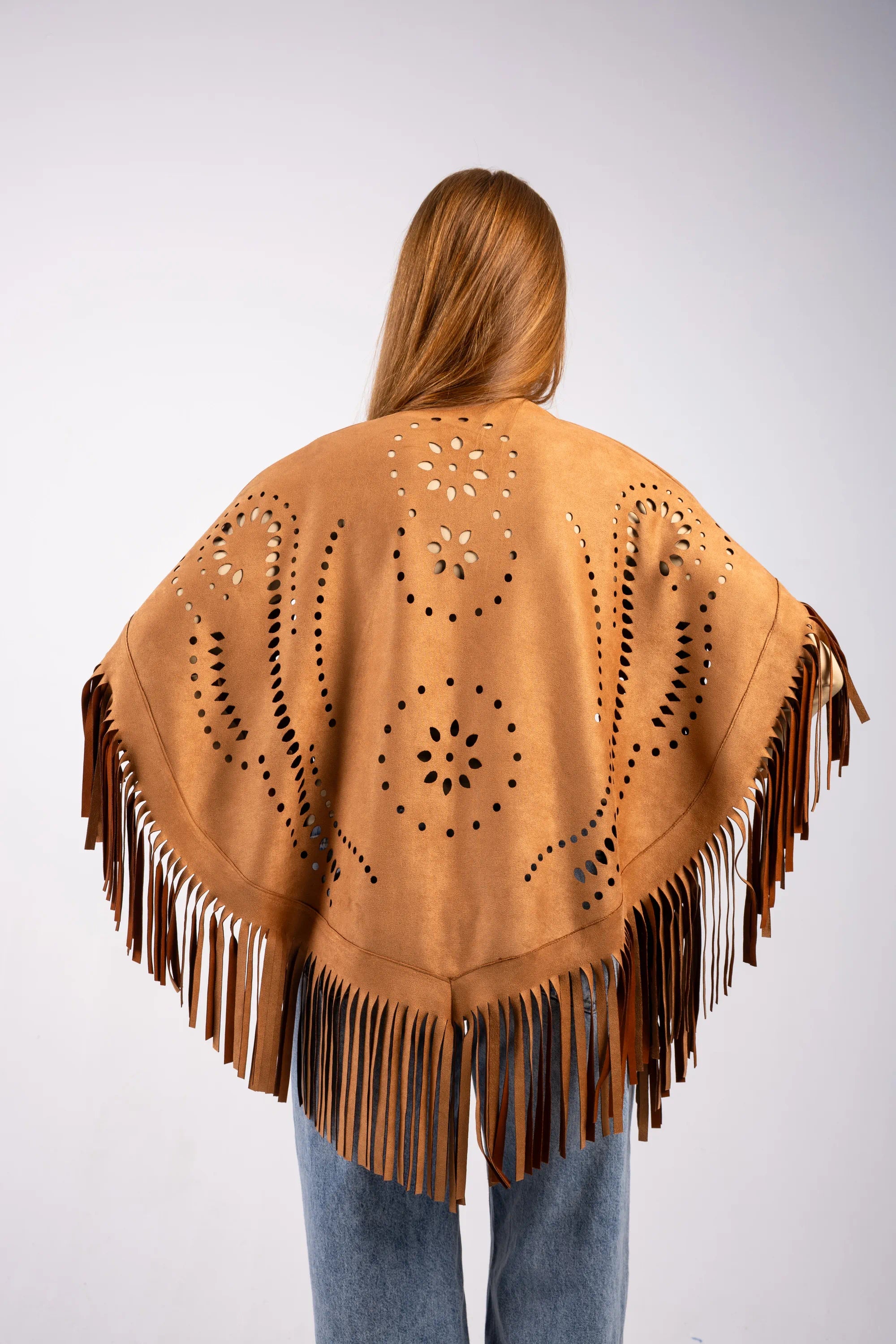Person wearing a brown fringe poncho with cut-out patterns on a white background