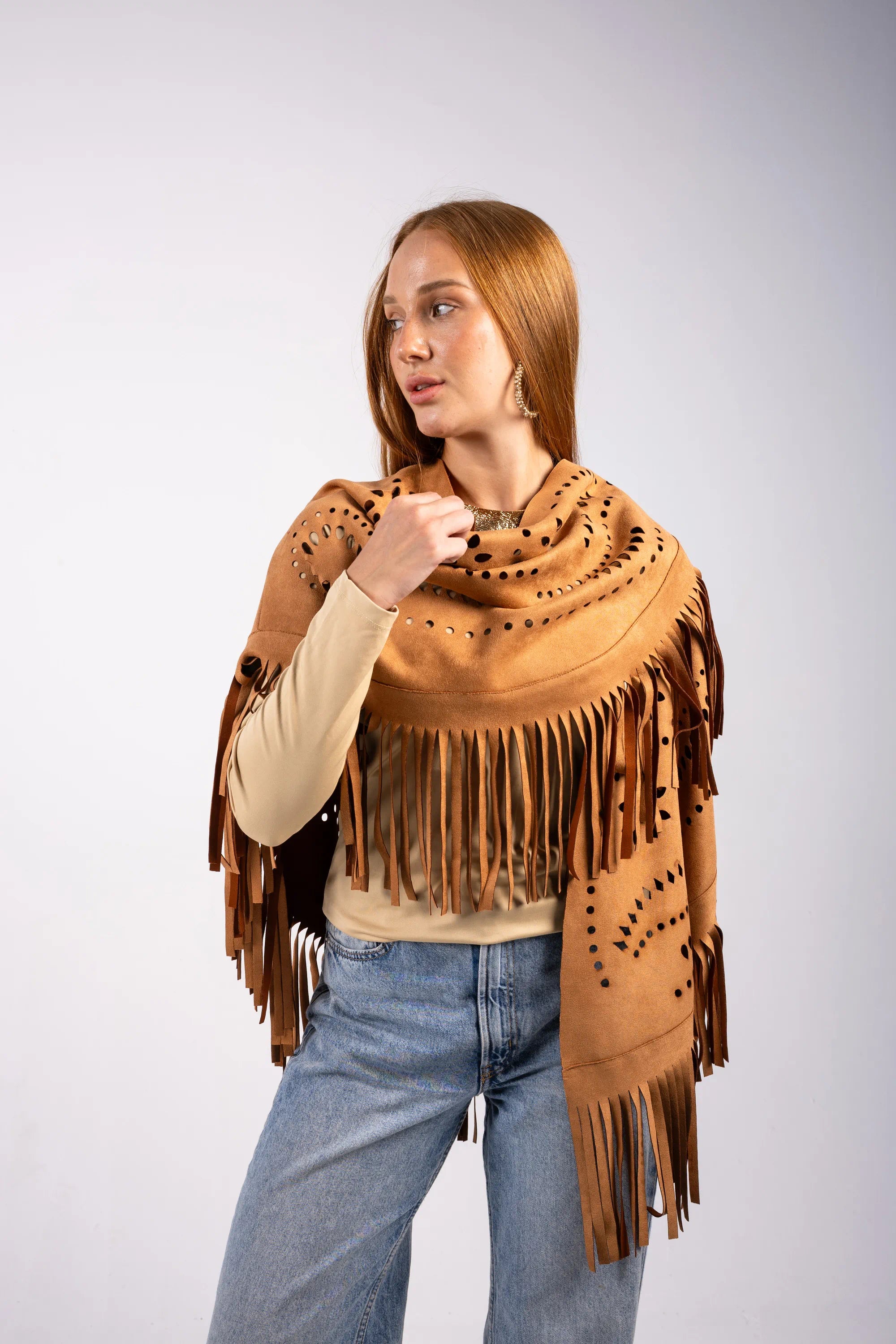 Woman wearing a brown leather fringe shawl on a white background