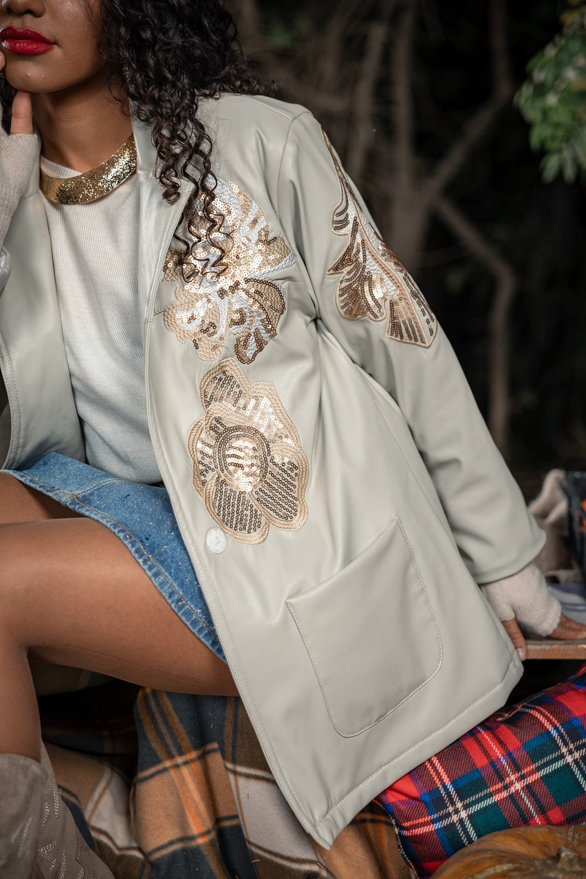 Woman wearing a light green embroidered jacket with a blurred background