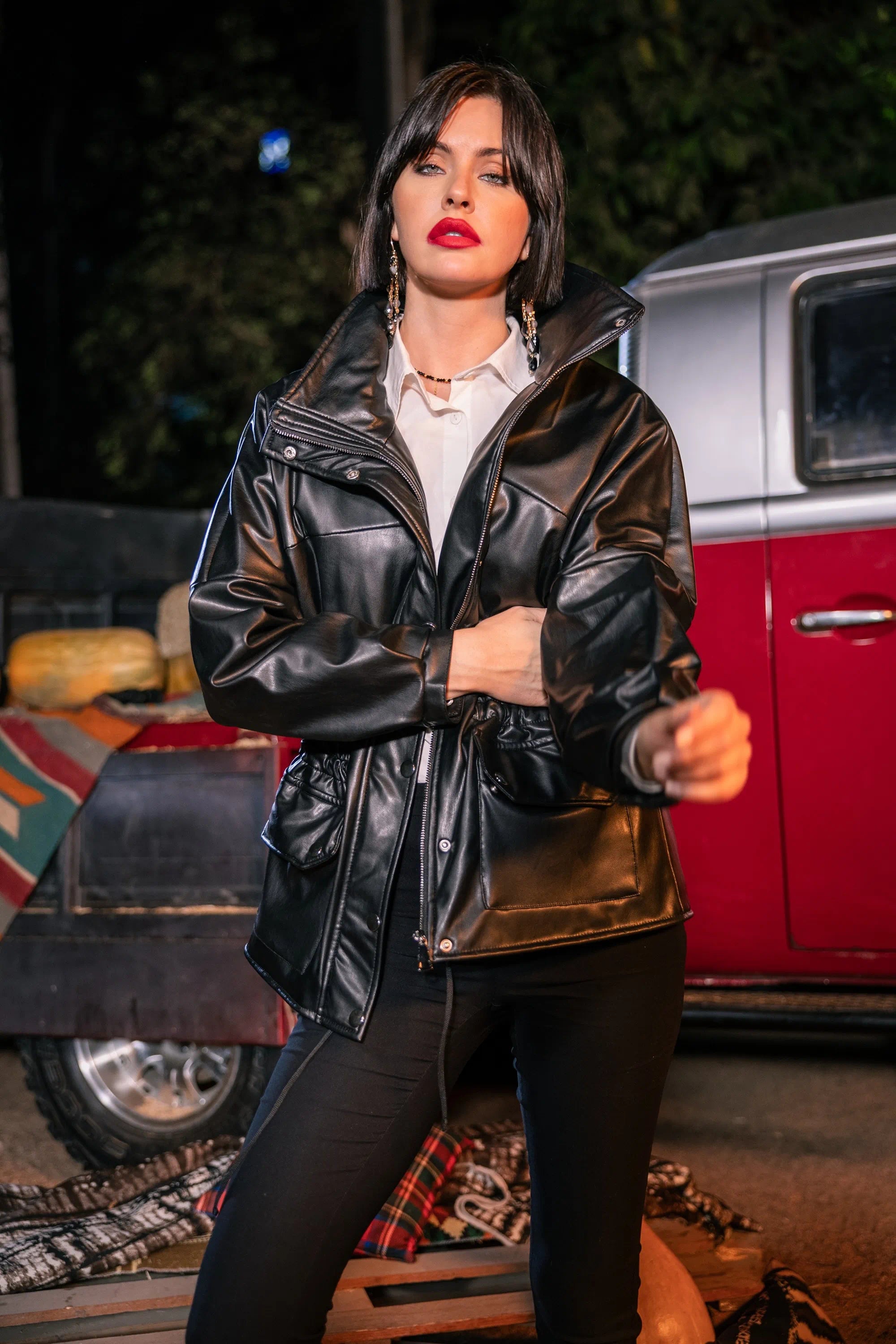 Woman wearing a black leather jacket in front of a vintage van
