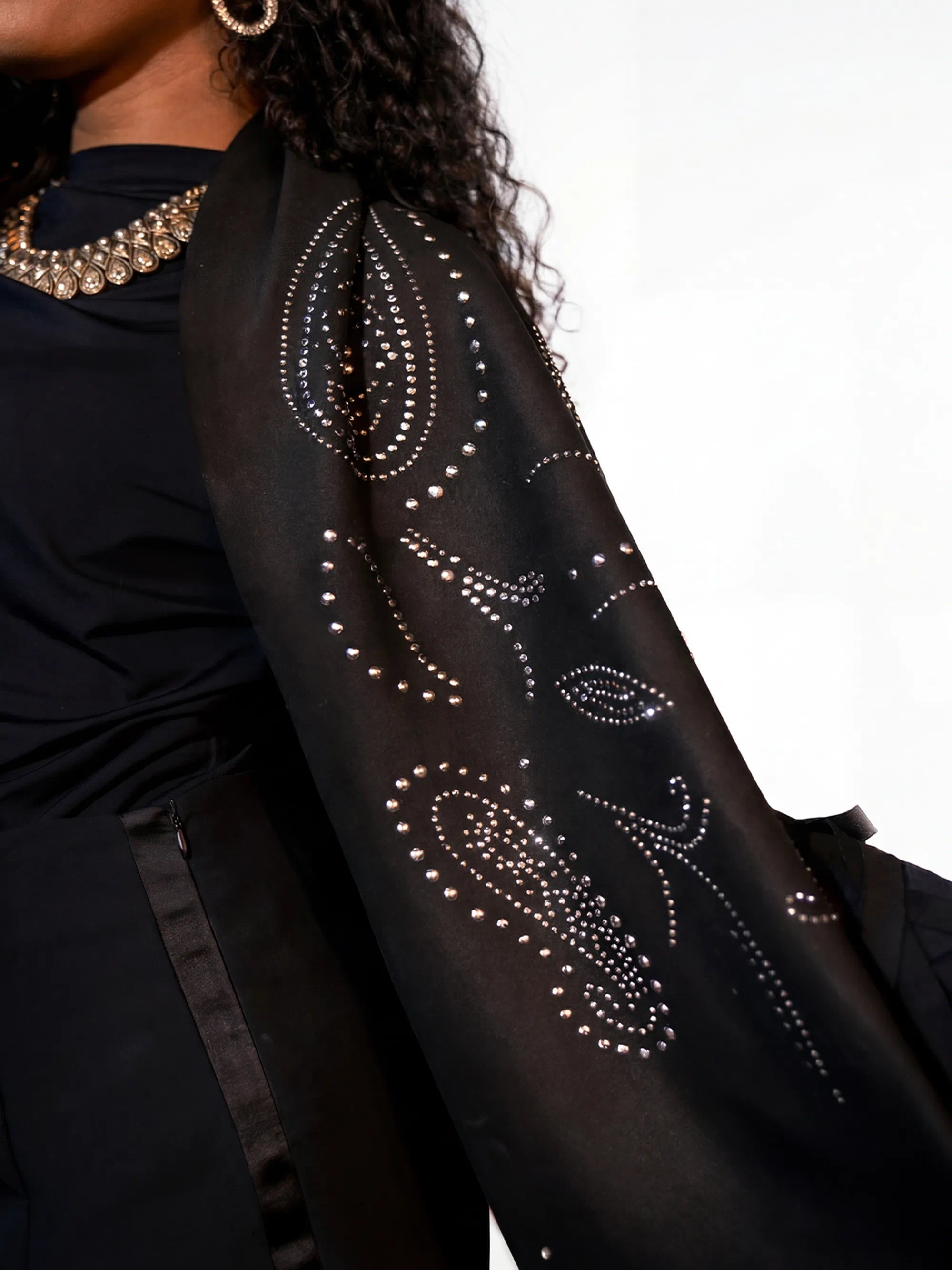 Black garment with decorative patterns on a white background