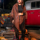 Woman standing in front of a vintage truck with pumpkins at night