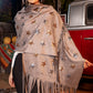 Woman wearing a star-patterned shawl with fringe in front of a vintage red truck.