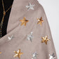 Gray scarf with gold and silver star patterns worn by a person.