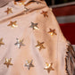 Close-up of a beige coat with star-shaped embellishments on a blurred background