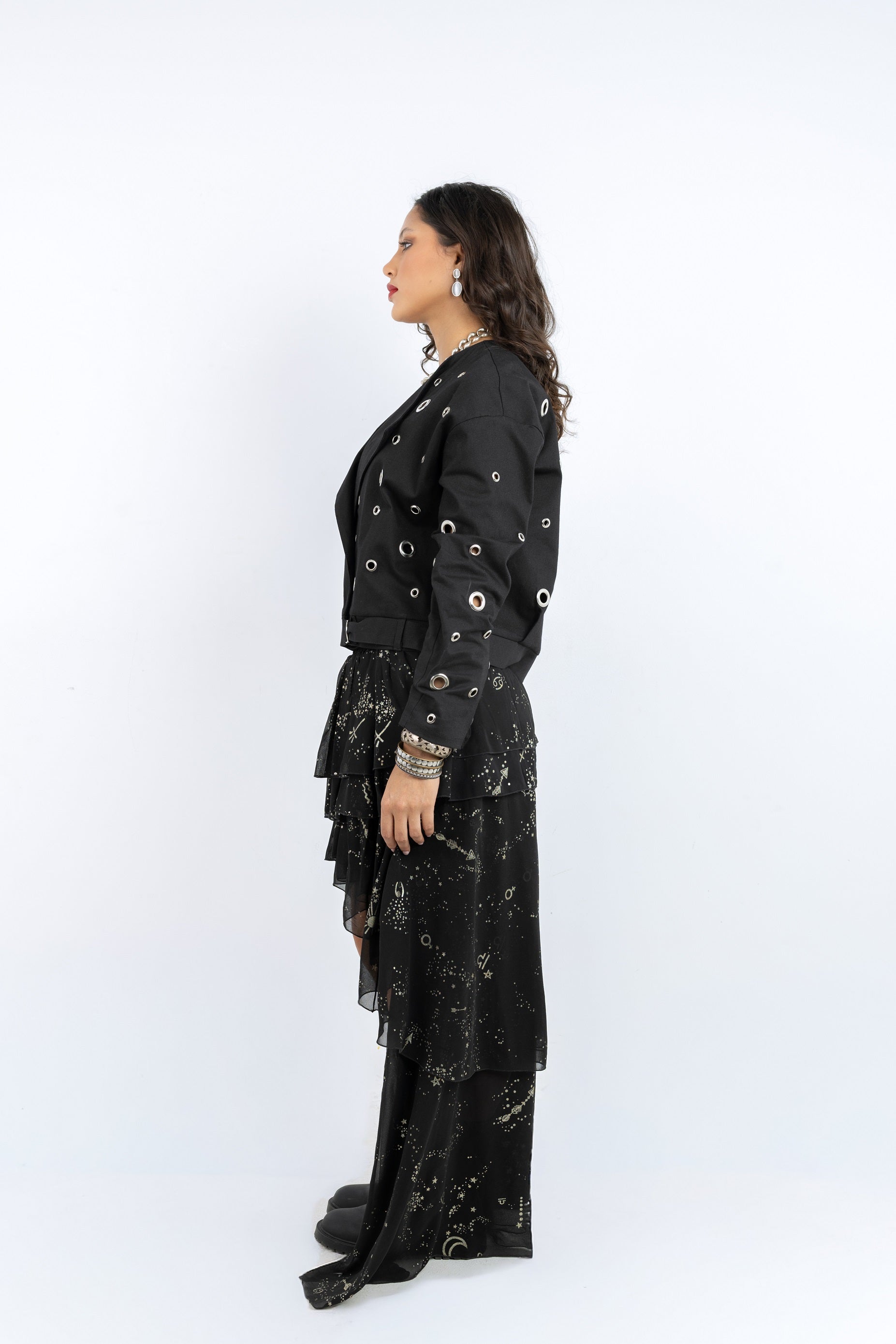 Woman wearing a black outfit with white patterns on a white background