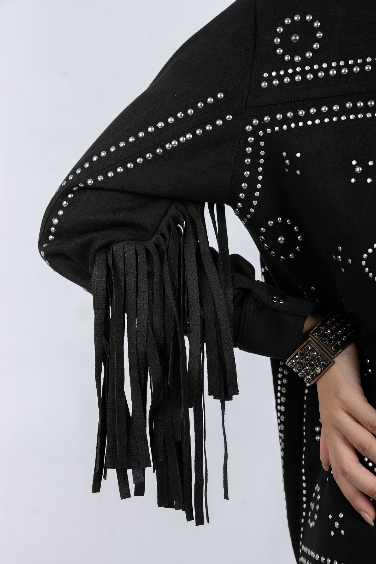 Black studded jacket with fringes on a white background