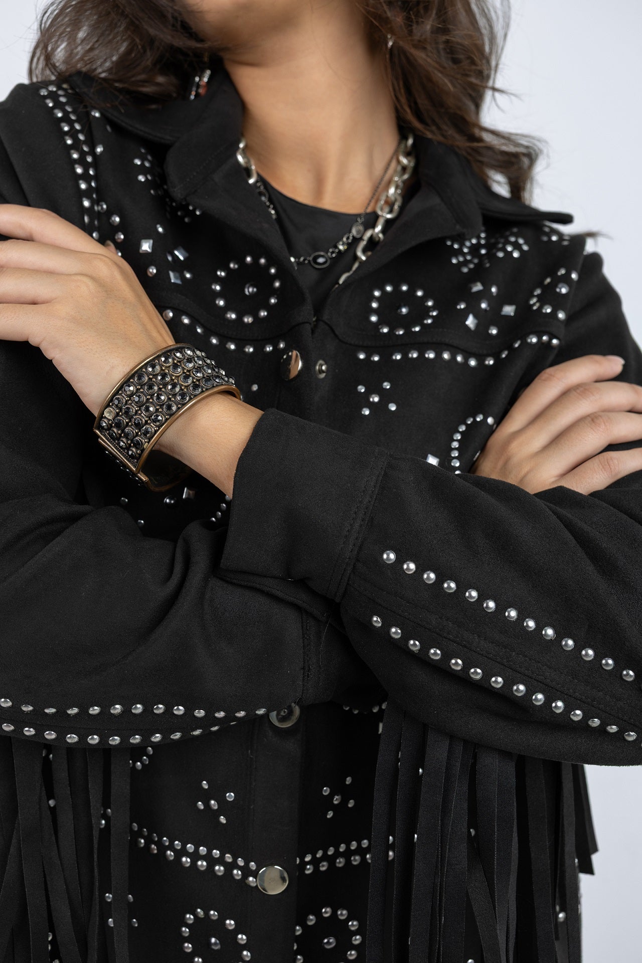 Black studded jacket with fringe details on a plain background