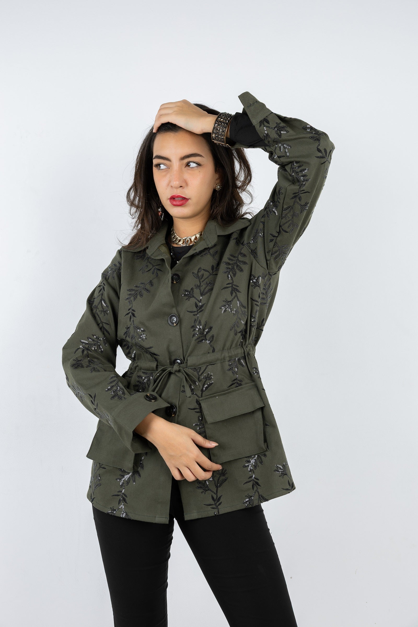 Woman wearing a green floral jacket against a white background