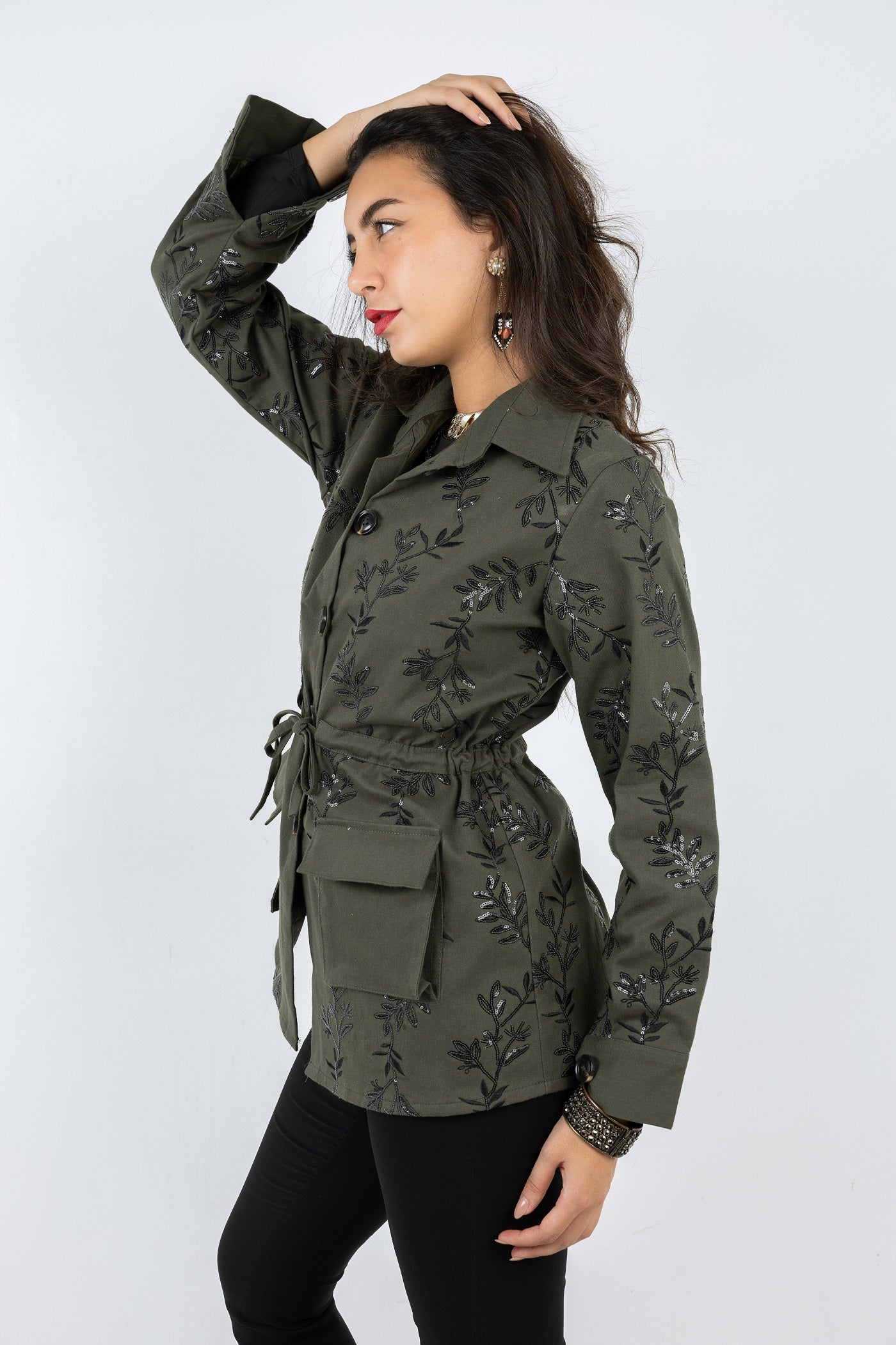 Woman wearing a green floral-patterned jacket on a white background