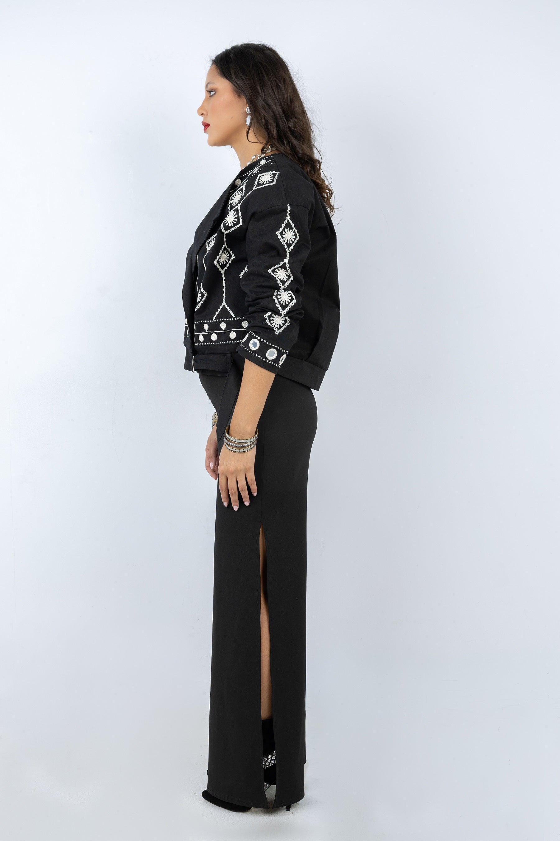 Woman wearing a black outfit with geometric patterns on a white background