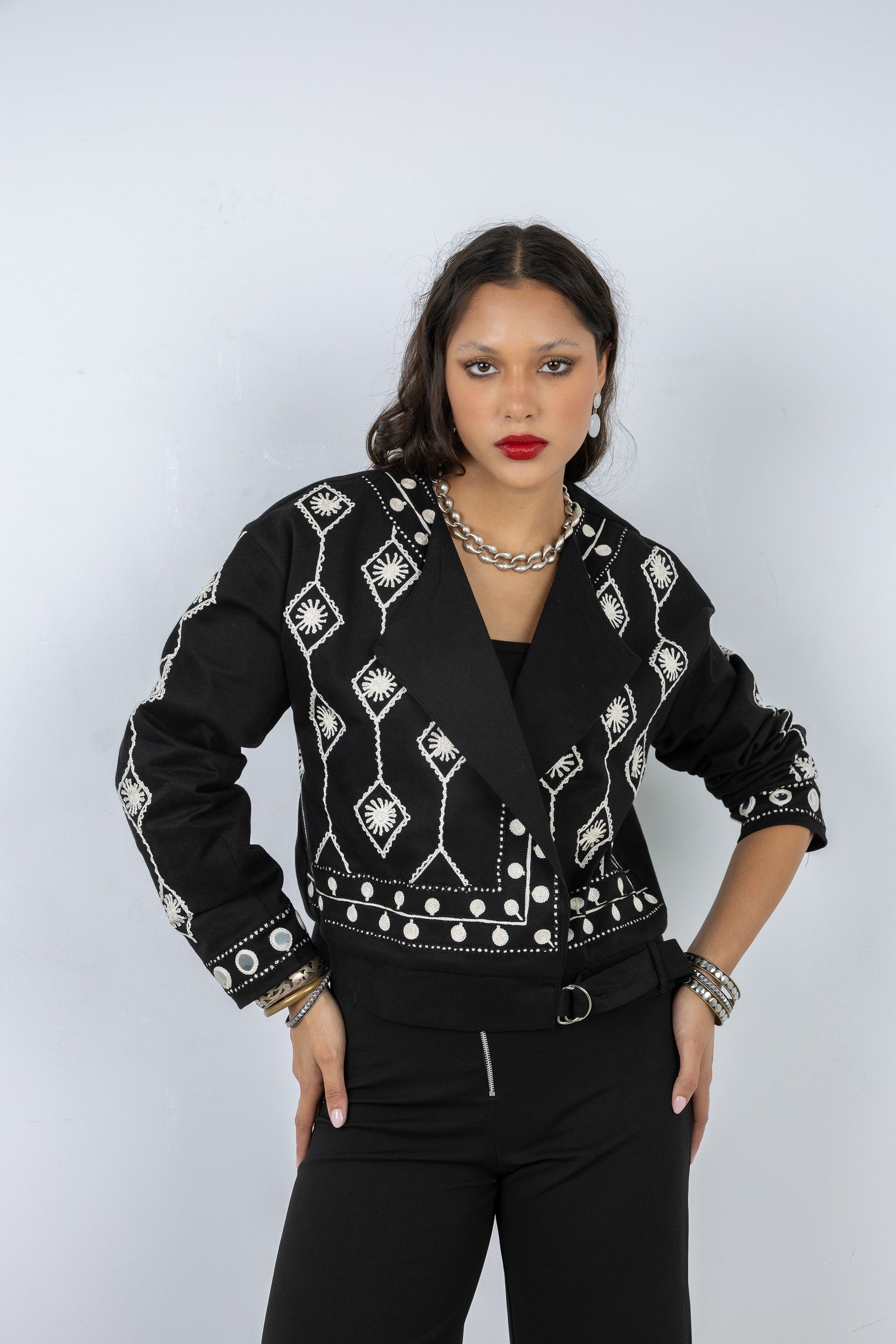 Woman wearing a black patterned jacket on a white background