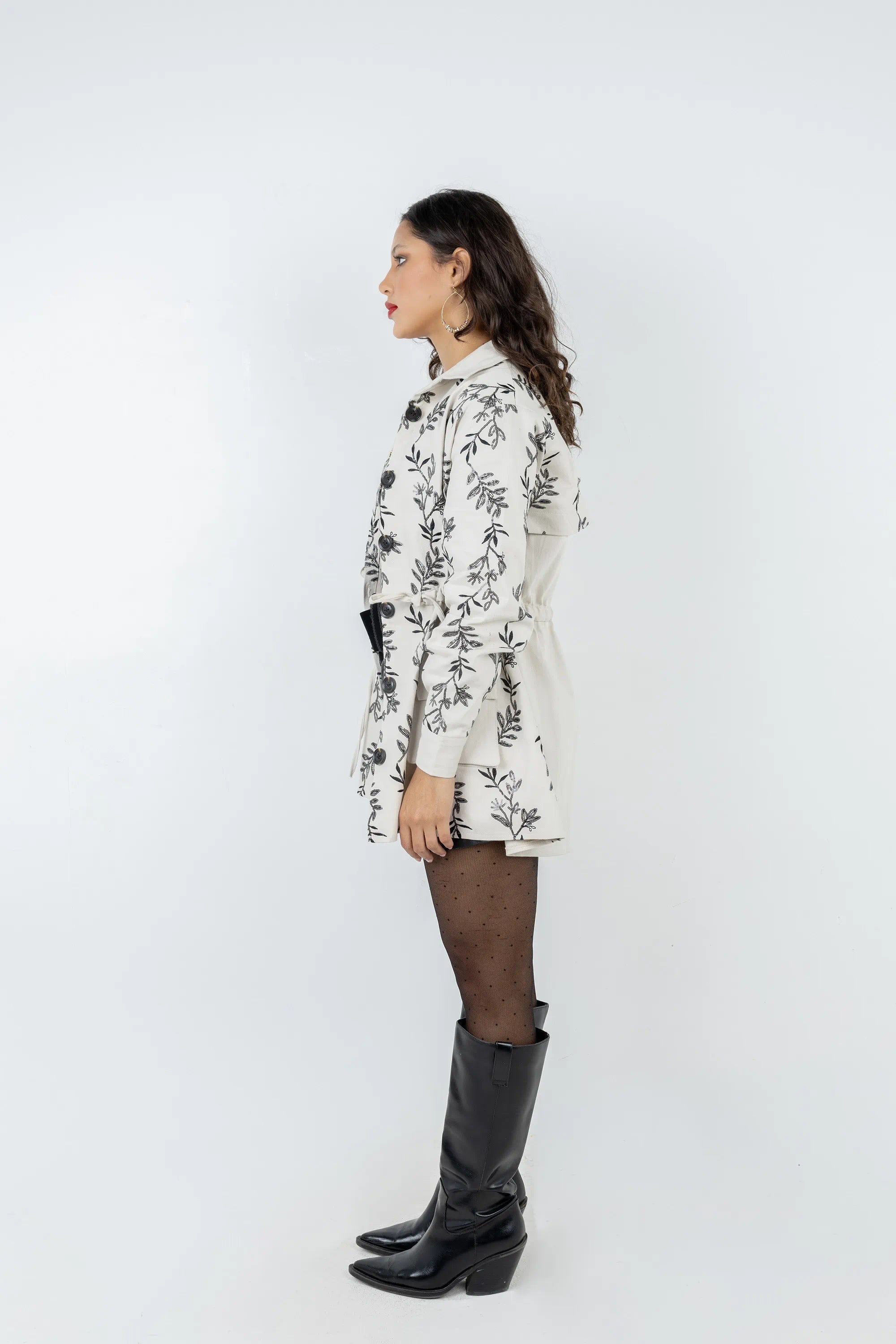 Woman wearing a white floral dress and black boots on a white background
