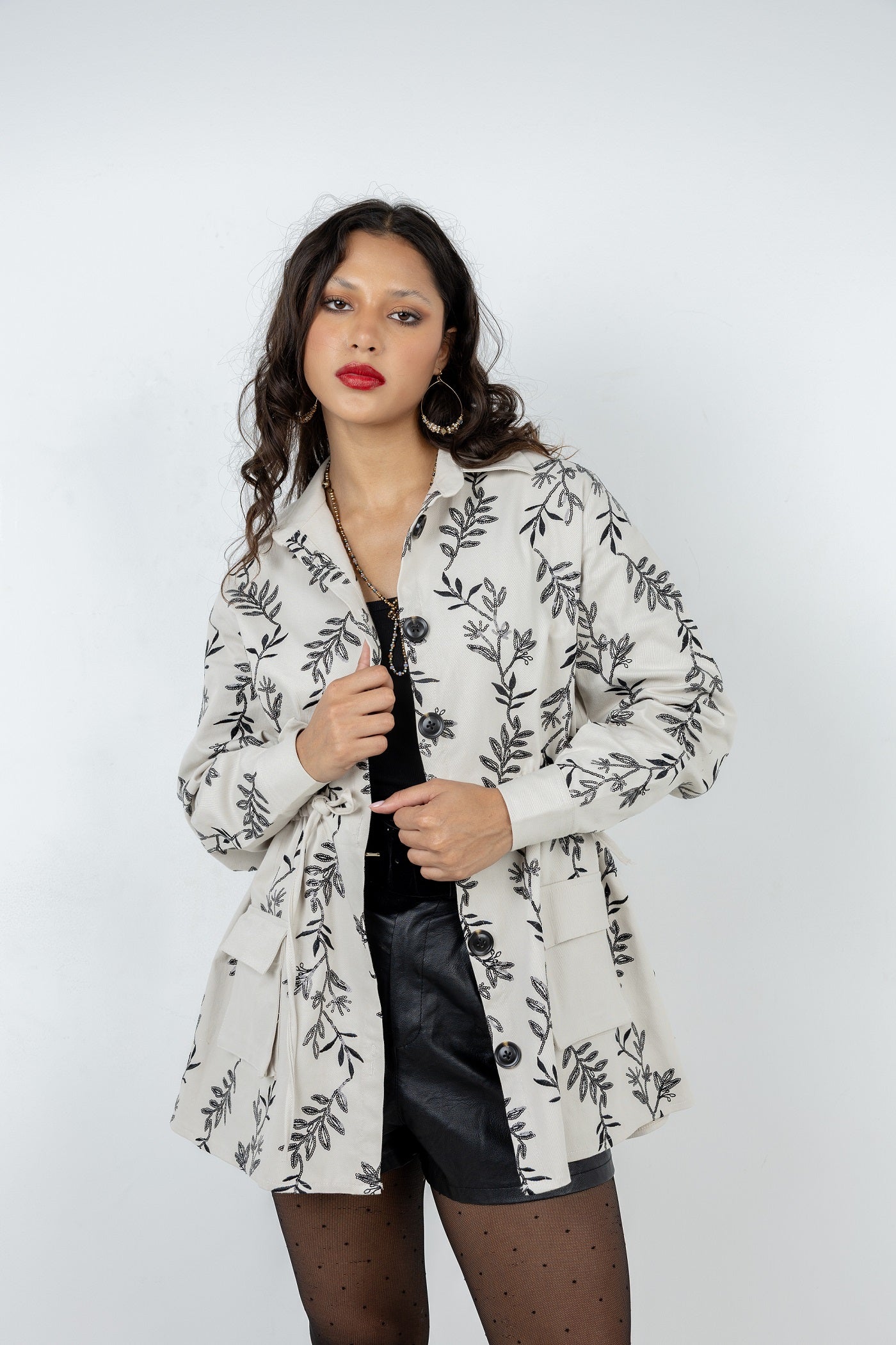 Woman wearing a floral-patterned coat against a white background