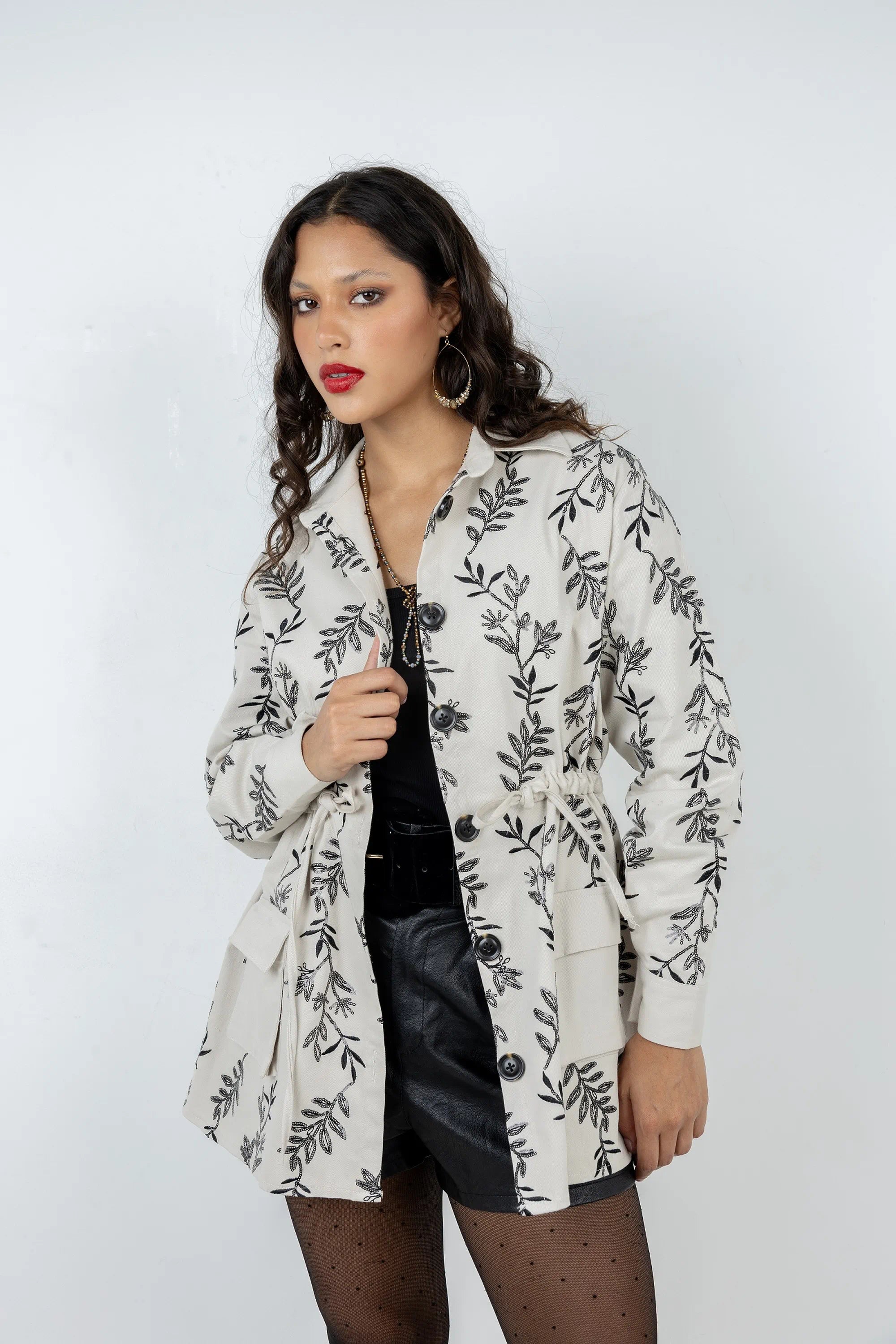 Woman wearing a floral-patterned blazer against a white background