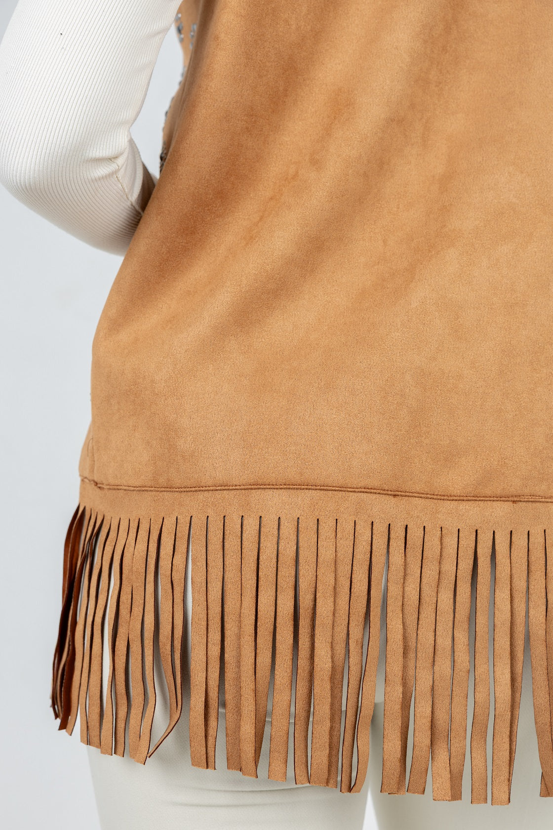 Tan suede vest with fringe on a white background