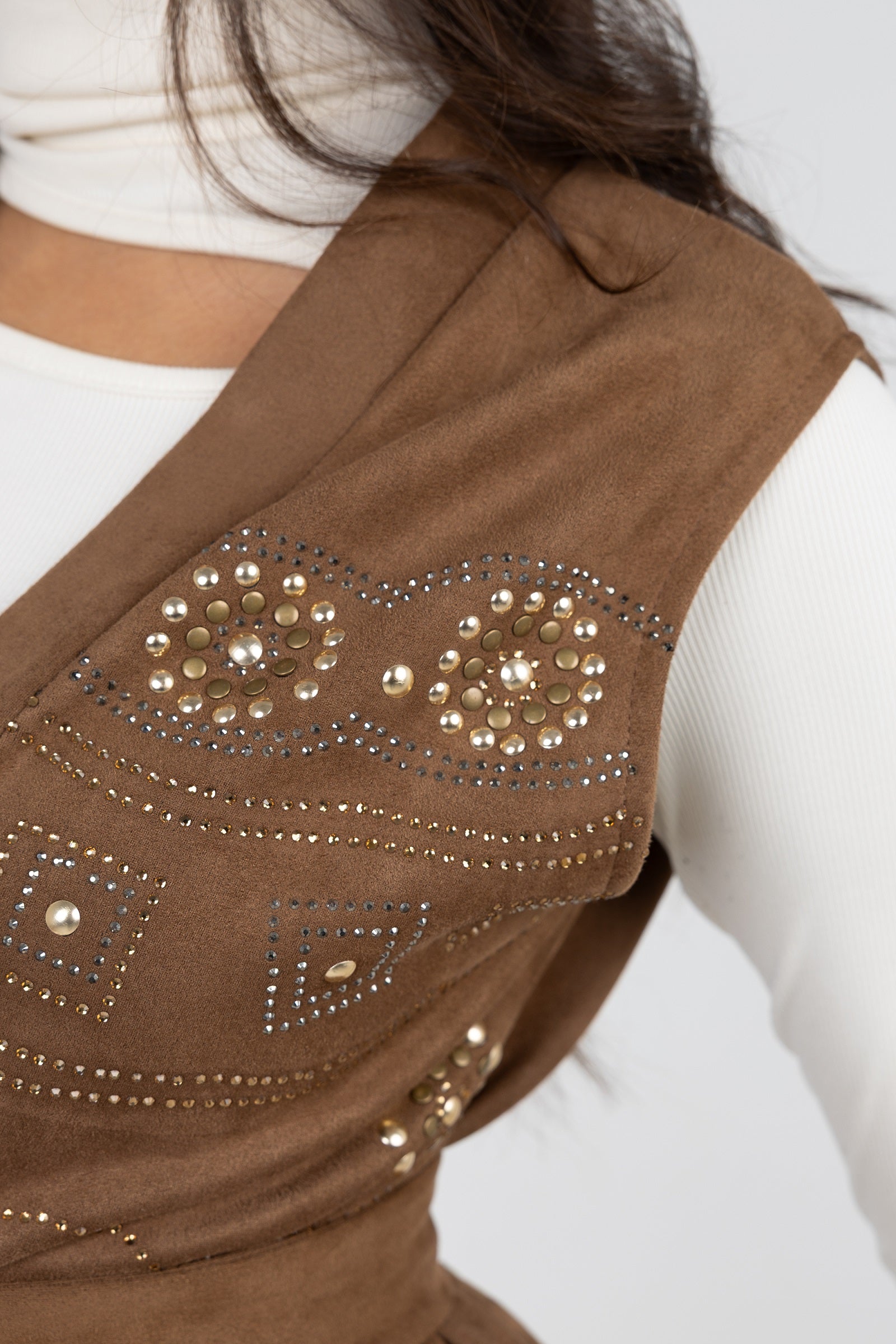 Brown vest with decorative studs on a white background