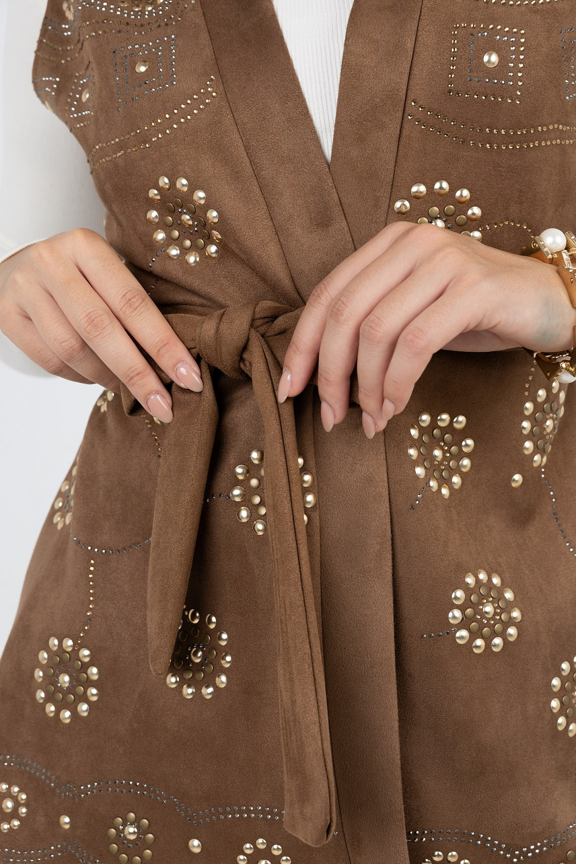 Brown fabric with gold embellishments and a tied knot, on a white background