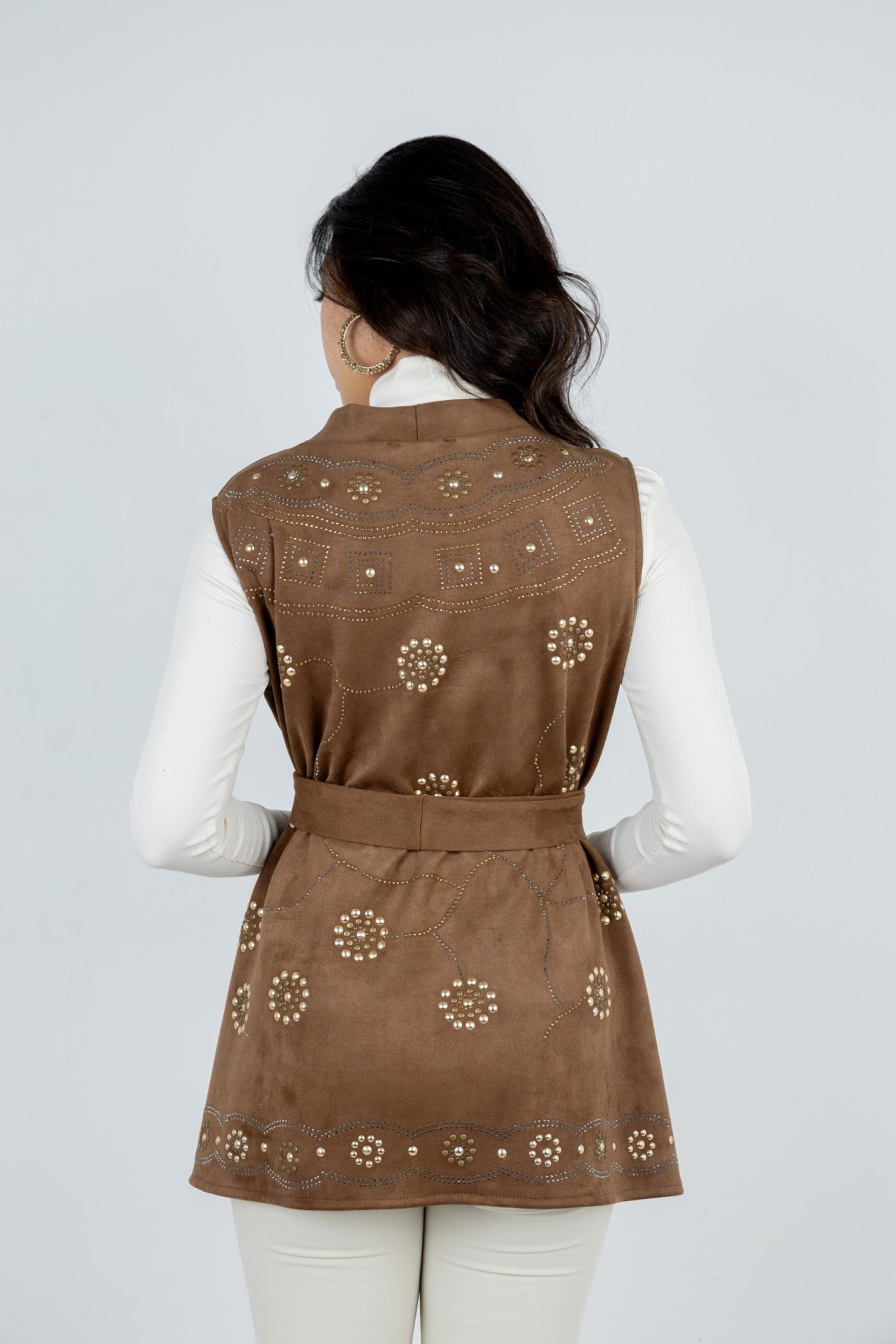 Woman wearing a brown embroidered vest on a white background