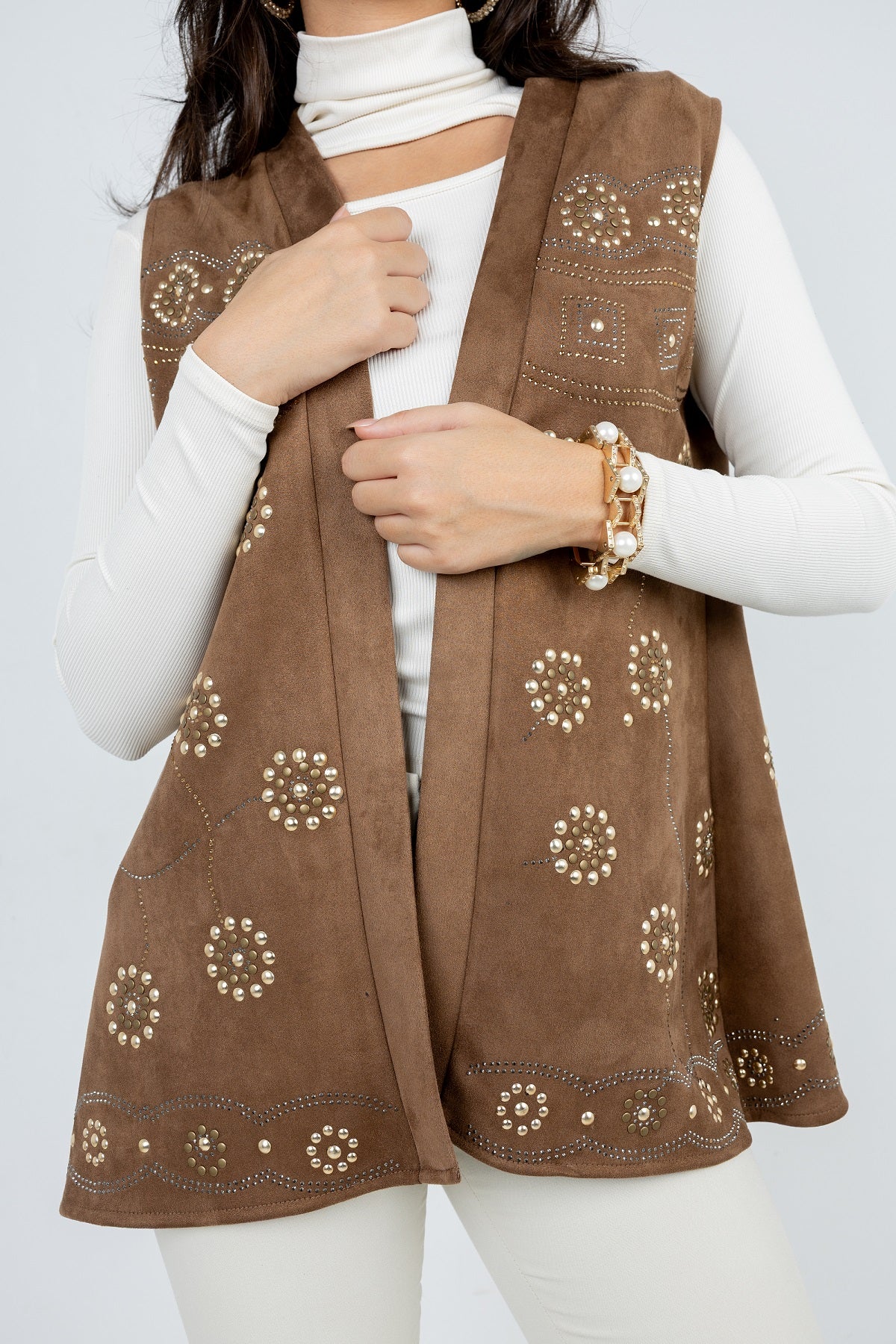 Brown embroidered vest worn by a person on a white background